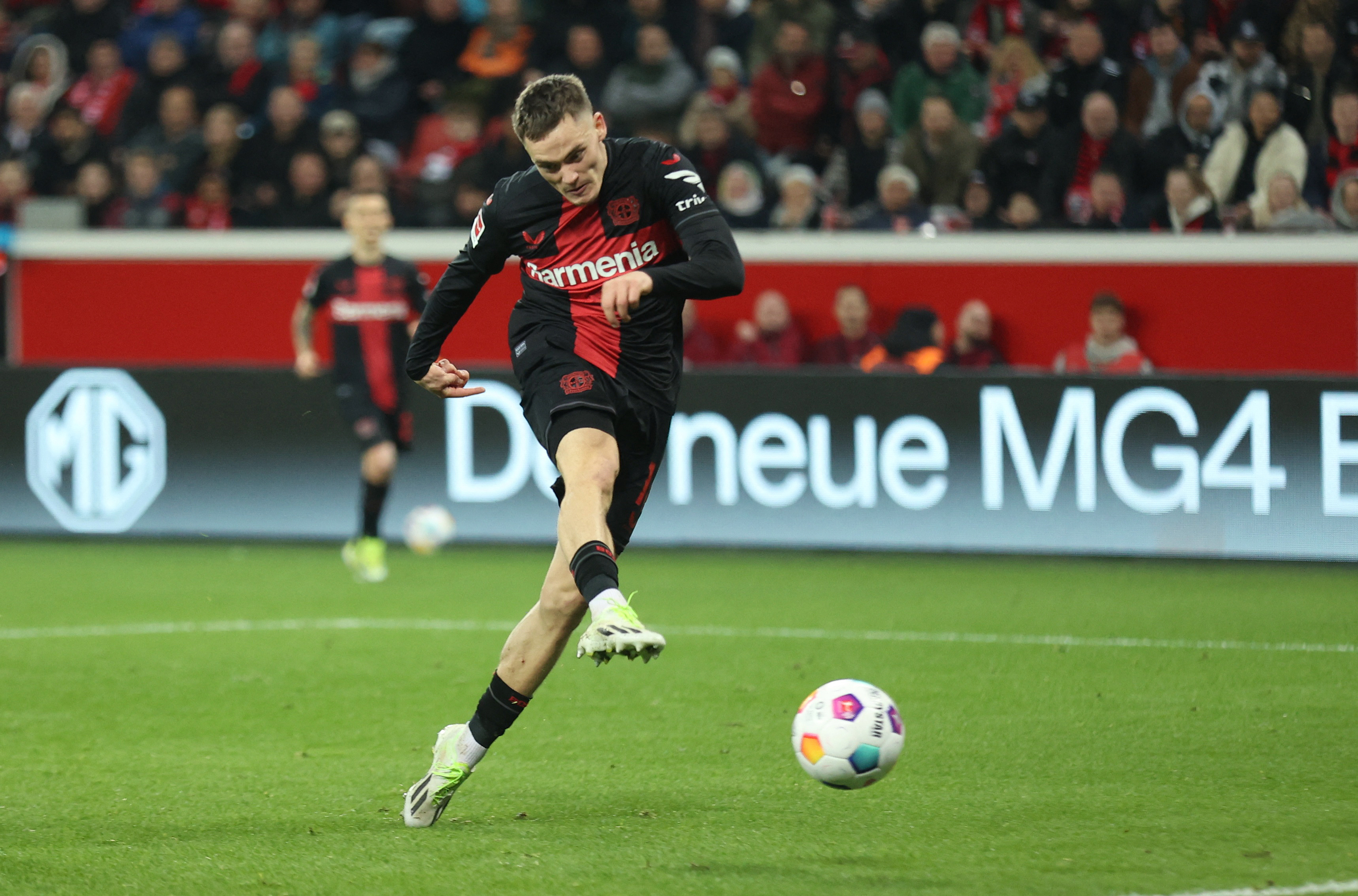 Football players kicks ball towards goal.