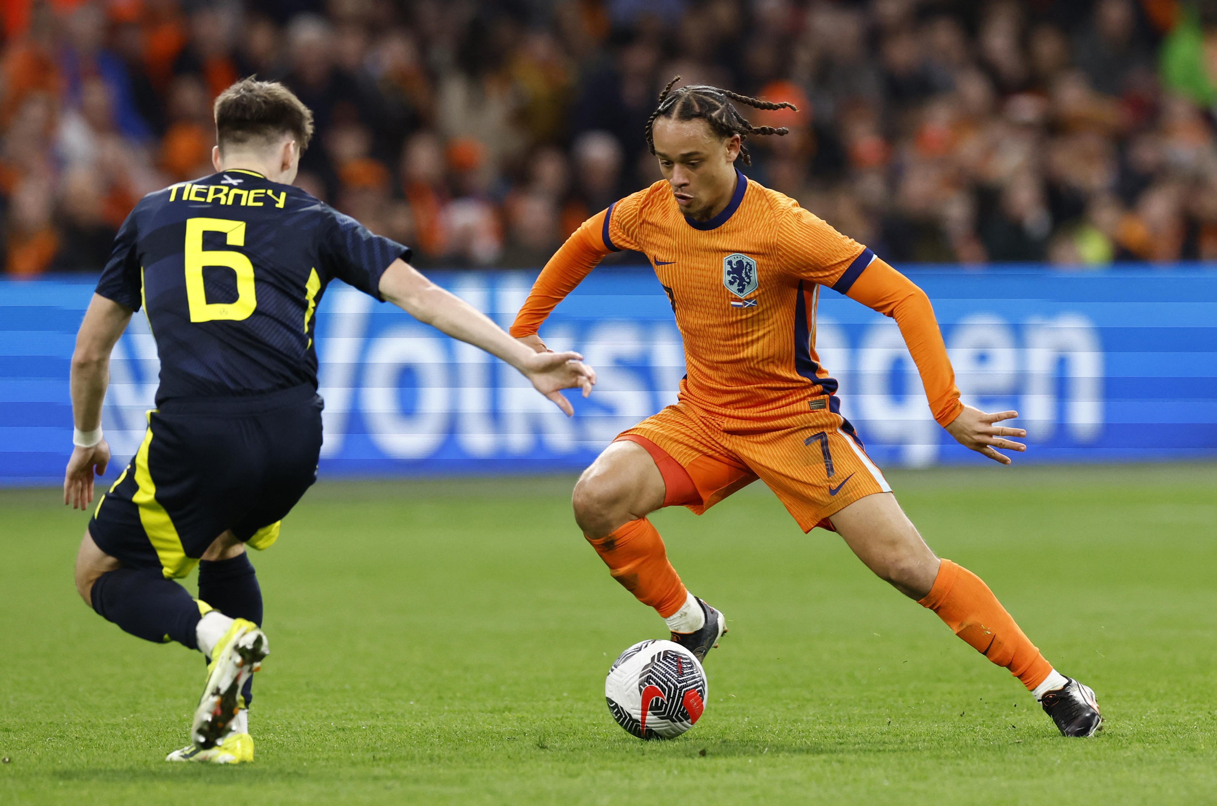 Football player dribbles around defender.