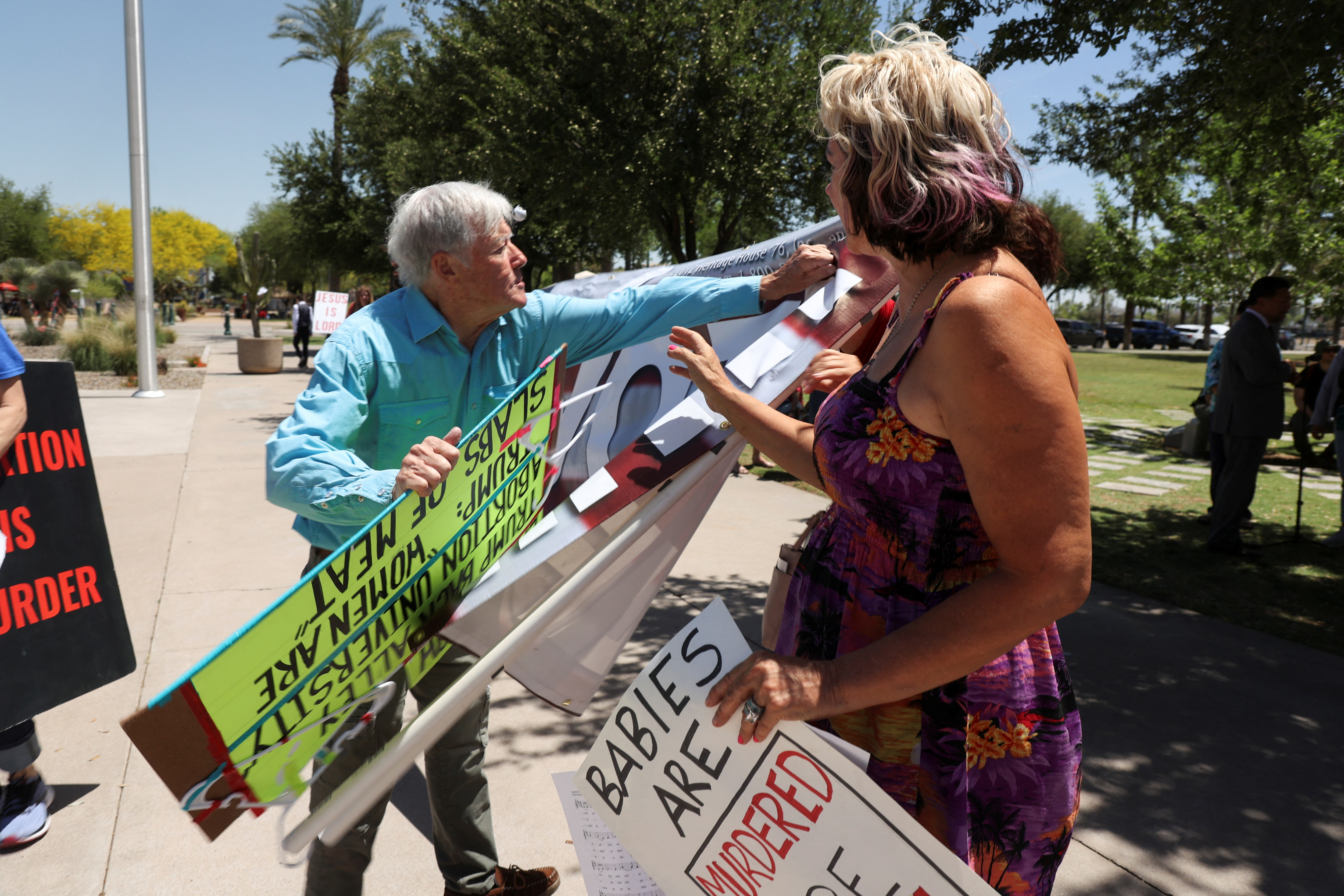 Pro and anti-abortion rights protesters argue outside the Arizona State Capitol as the Senate votes to repeal an 1864 abortion ban