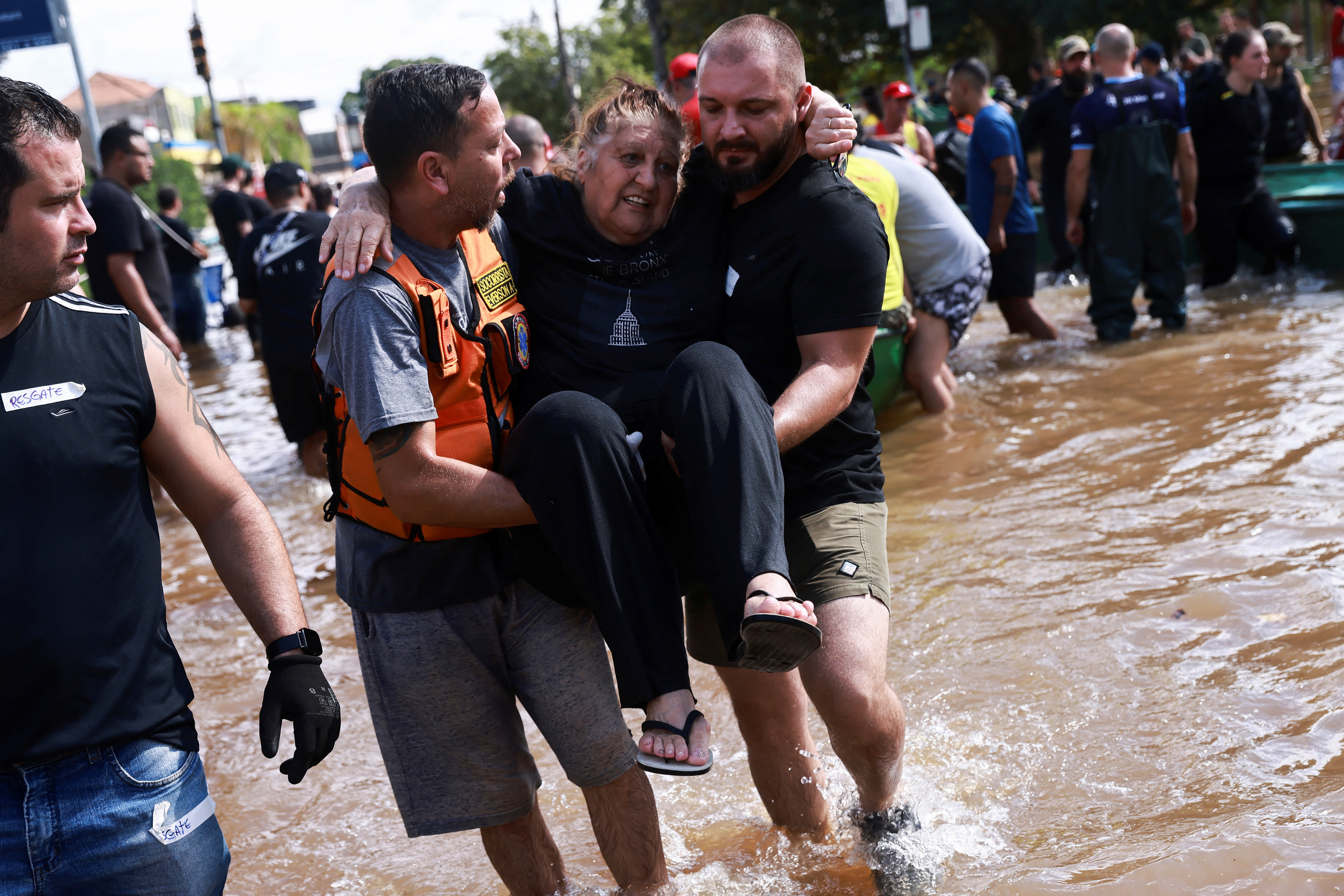 A woman is carried by rescuers amid flooding in Humaita, in Porto Alegre, Brazil