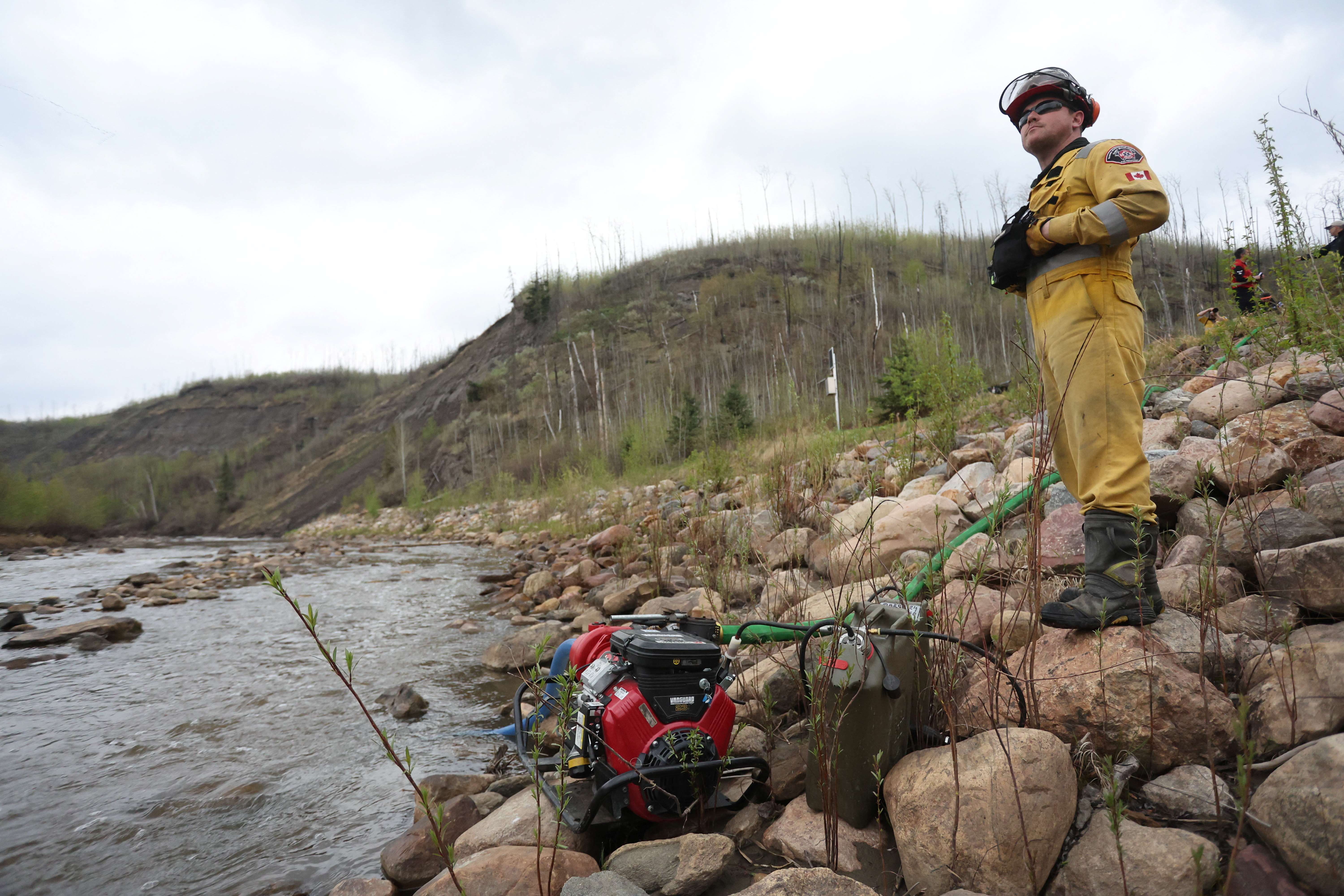 A firefighter monitors a pump in Fort McMurray, Canada