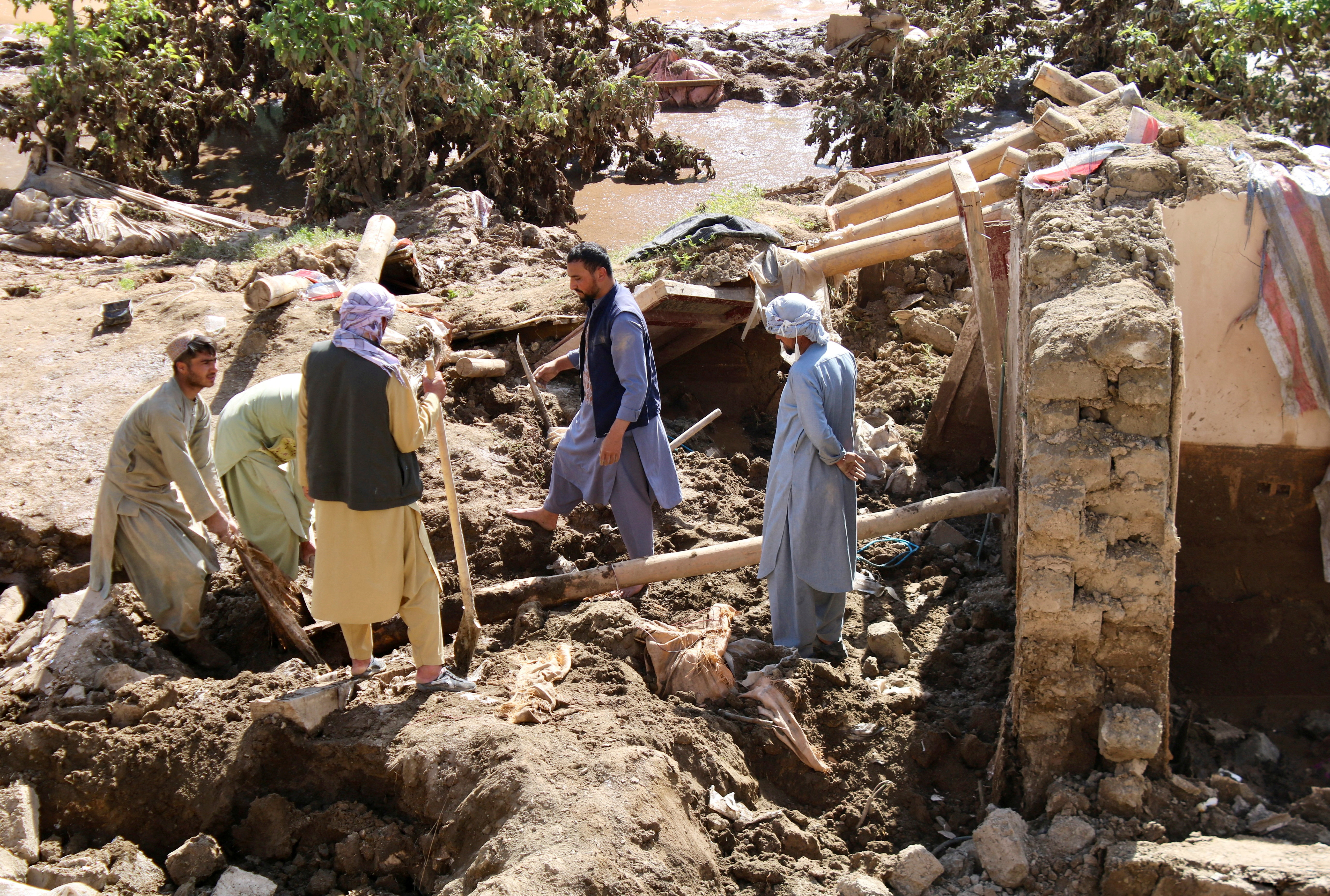 People remove debris from a house damaged by the flood in Firozkoh the capital city of Ghor Province, Afghanistan, May 18, 2024. REUTERS/Stringer