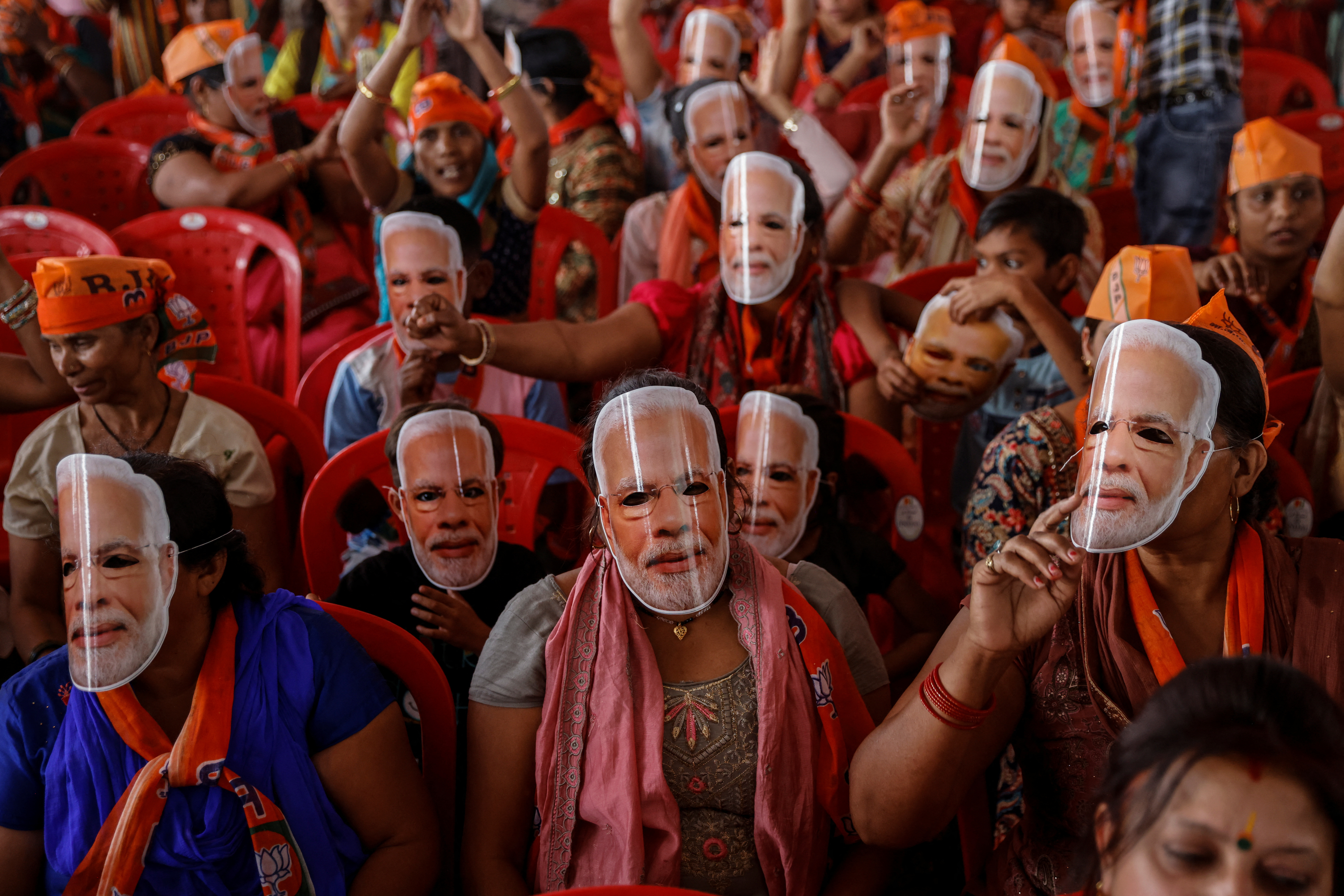 Supporters of India's Prime Minister Narendra Modi wear masks of his face, as they attend an election campaign rally in Meerut, India