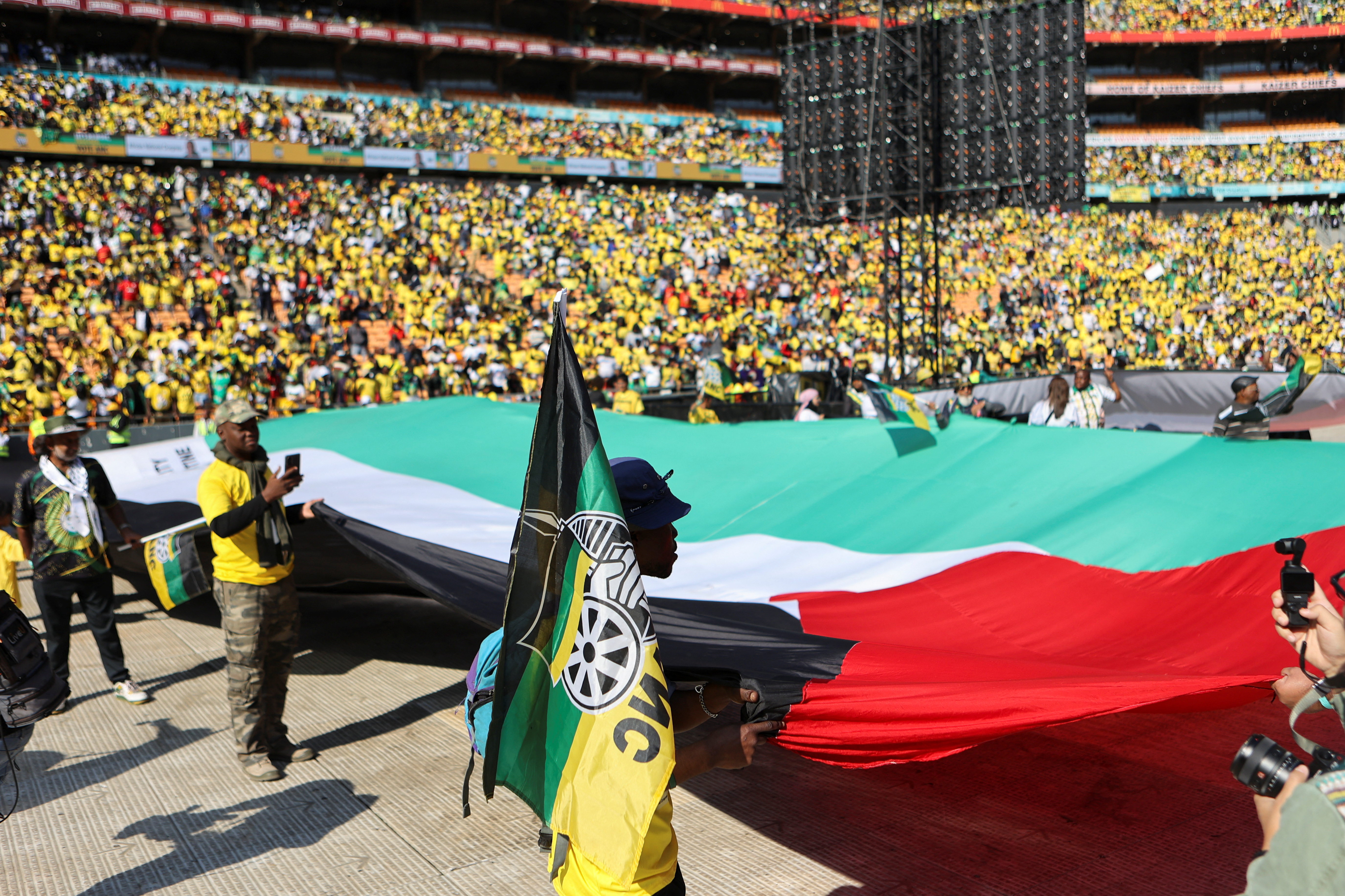 Supporters of the African National Congress (ANC) hold out a Palestinian flag during their final rally ahead of the upcoming election at FNB stadium in Johannesburg, South Africa, May 25, 2024. REUTERS/Alaister Russell