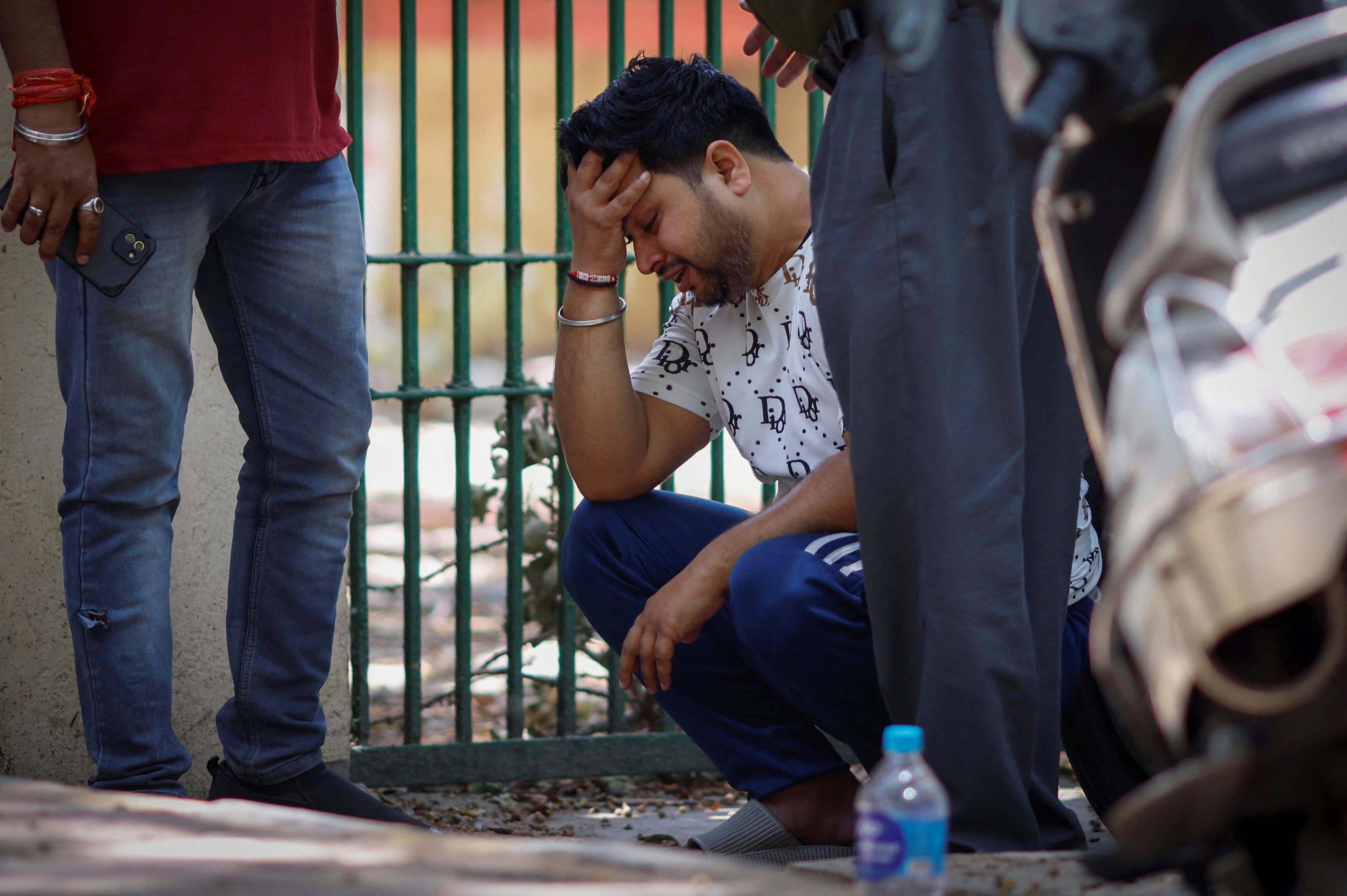 Vinod Kumar cries outside a hospital morgue after his newborn child went missing following a fire at a baby care hospital,