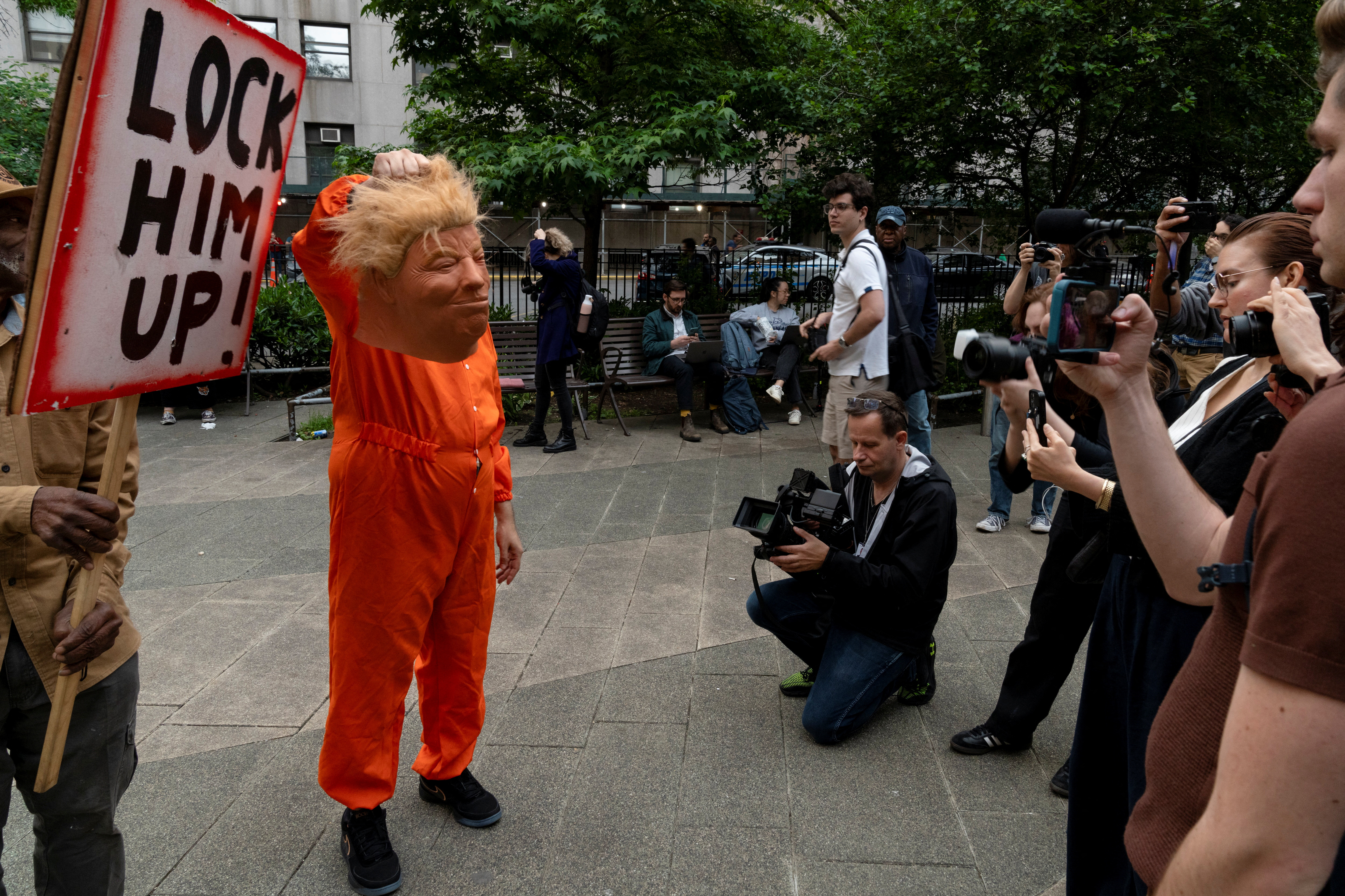 A person holds a mask while impersonating Republican presidential candidate and former U.S. President Donald Trump outside the Manhattan criminal court following the announcement of the verdict in Trump's criminal trial over charges that he falsified business records to conceal money paid to silence porn star Stormy Daniels in 2016, in New York City, U.S. May 30, 2024. REUTERS/Cheney Orr