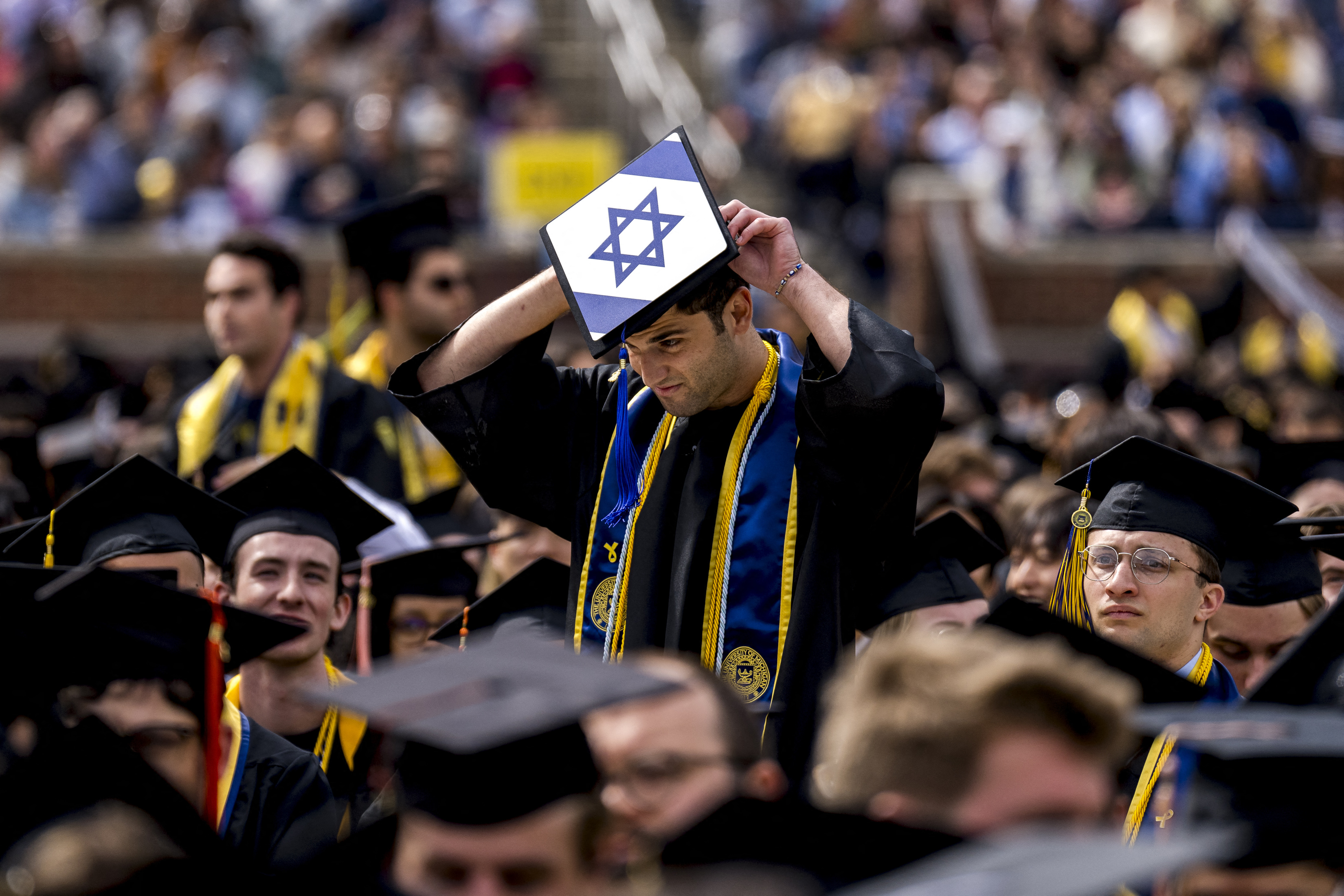 A student wears a graduation cap with the Flag of Israel during a Pro-Palestinian protest during the University of Michigan's spring commencement ceremony