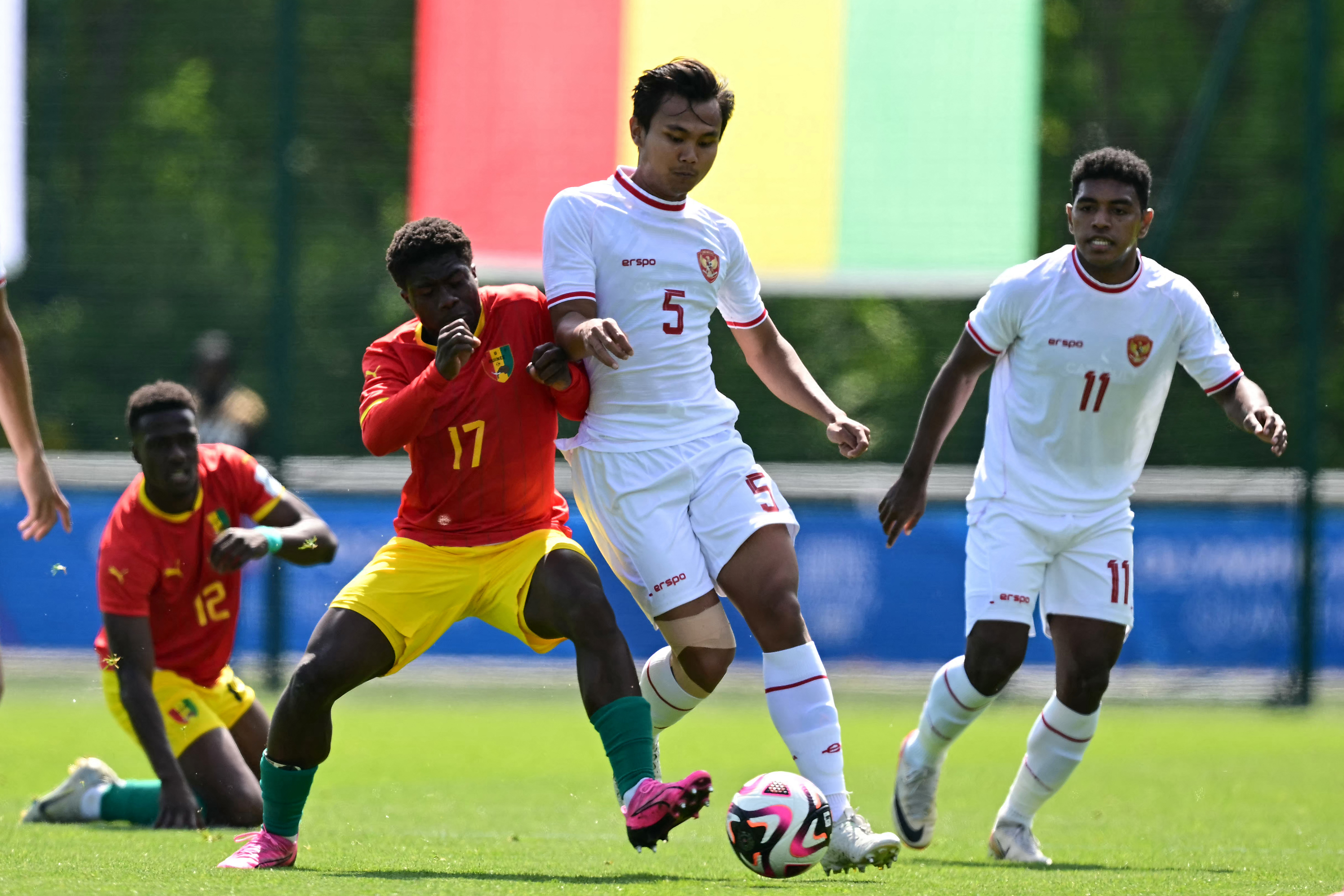 Indonesia's defender#05 Komang Teguh (C) fights for the ball with Guinea's midfielder #17 Issiaga Camara