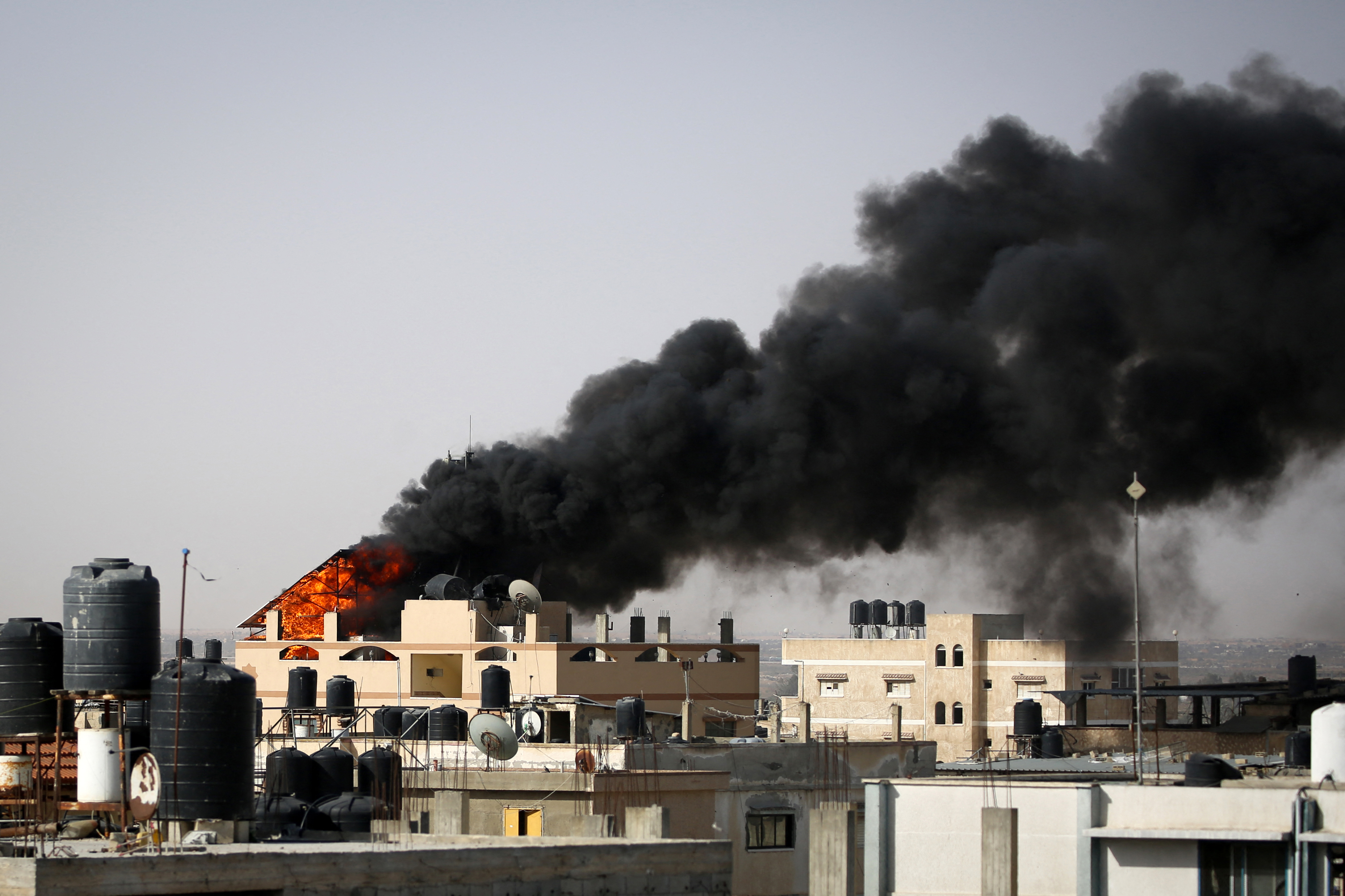 Thick, black smoke rises from a fire in a building caused by Israeli bombardment in Rafah in the southern Gaza Strip