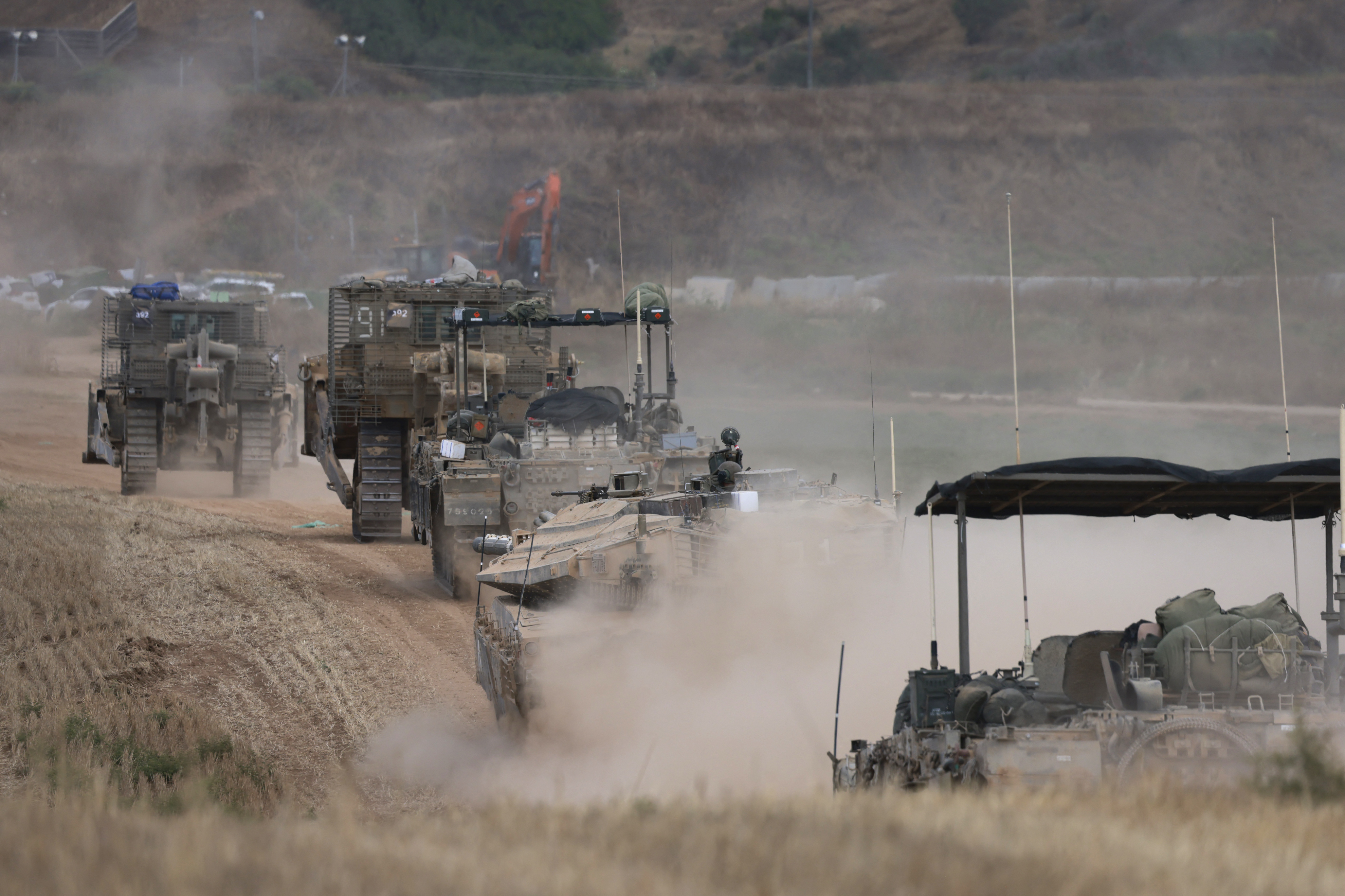 Israeli military vehicles roll near the border with the Gaza Strip on May 12, 2024, amid the ongoing conflict between Israel and the Palestinian Hamas movement. (Photo by Menahem KAHANA / AFP)