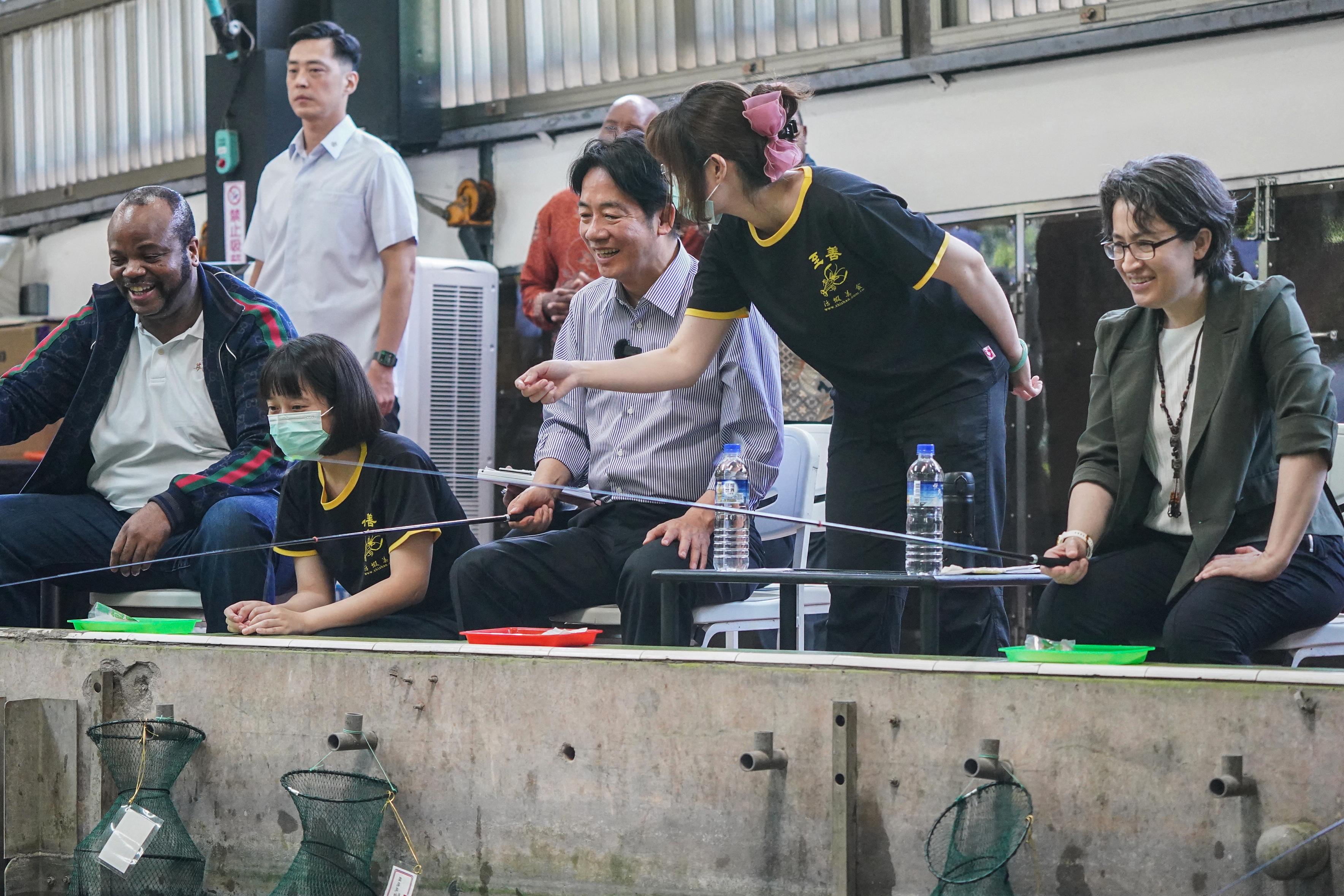King Mswati III of Eswatini (L), Taiwan's President-elect Lai Ching-te (C) and Taiwan's Vice President-elect Hsiao Bi-khim (R) fish at the Zhishan Shrimp Fishing Farm in Taipei on May 19, 2024. Taiwan's President-elect Lai Ching-te and his deputy Hsiao Bi-khim hauled visiting foreign dignitaries, including presidents and a king, along for the fishing expedition at the Zhishan Shrimp Fishing Farm in the capital Taipei on May 19. (Photo by Aden HSU / POOL / AFP)