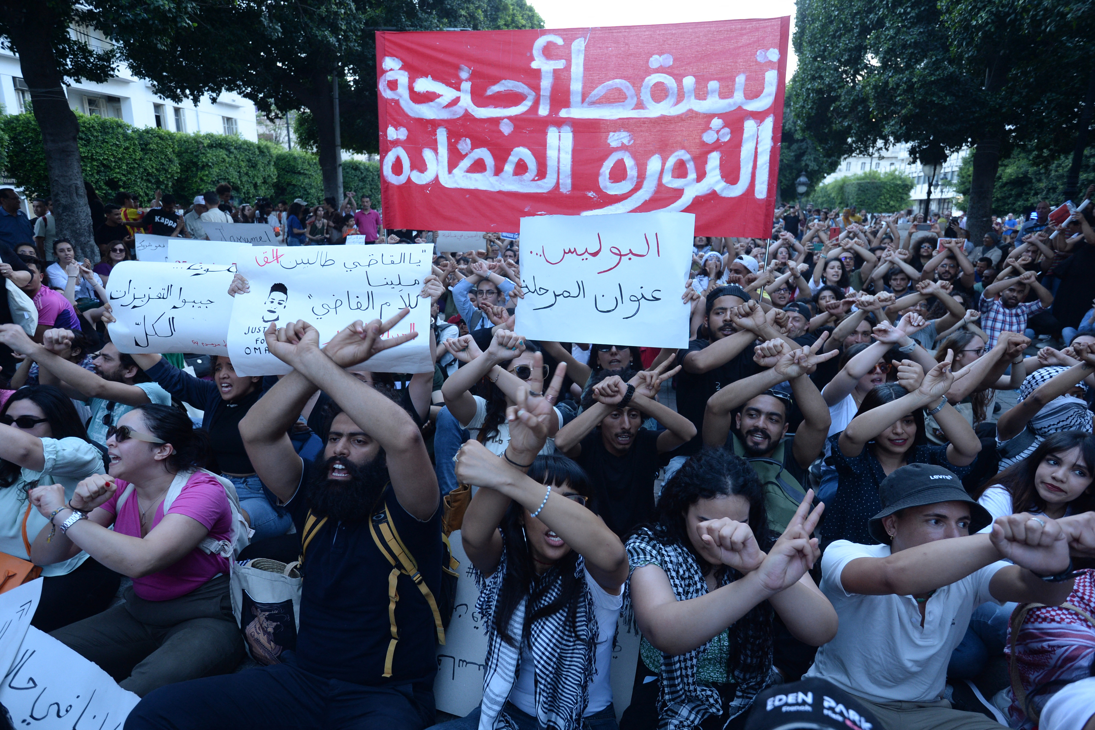 Tunisians block a street during a demonstration in Tunis on May 24, 2024. Several hundred Tunisians marched through the capital chanting "down with the dictatorship" as they protested a spate of arrests under a presidential decree critics say is being used to stifle dissent. (Photo by Sofiene HAMDAOUI / AFP)