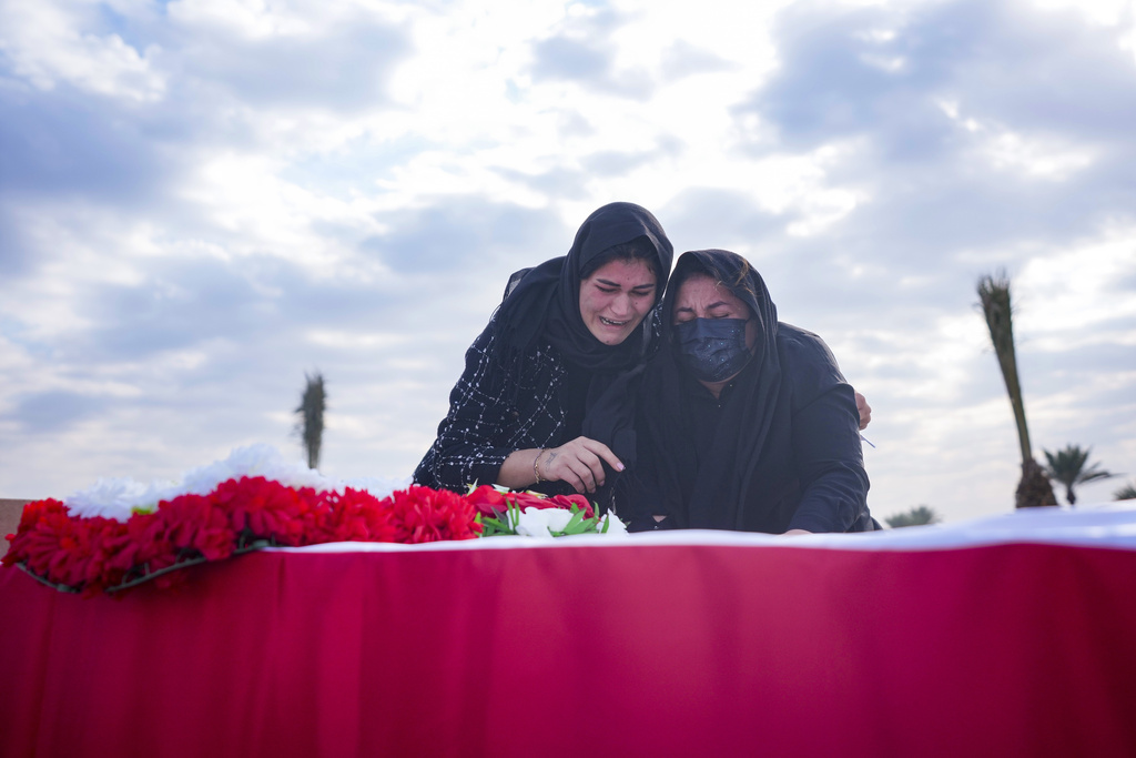 Relatives react near the body remains of people from the minority Yazidi, who were killed by Islamic State militants