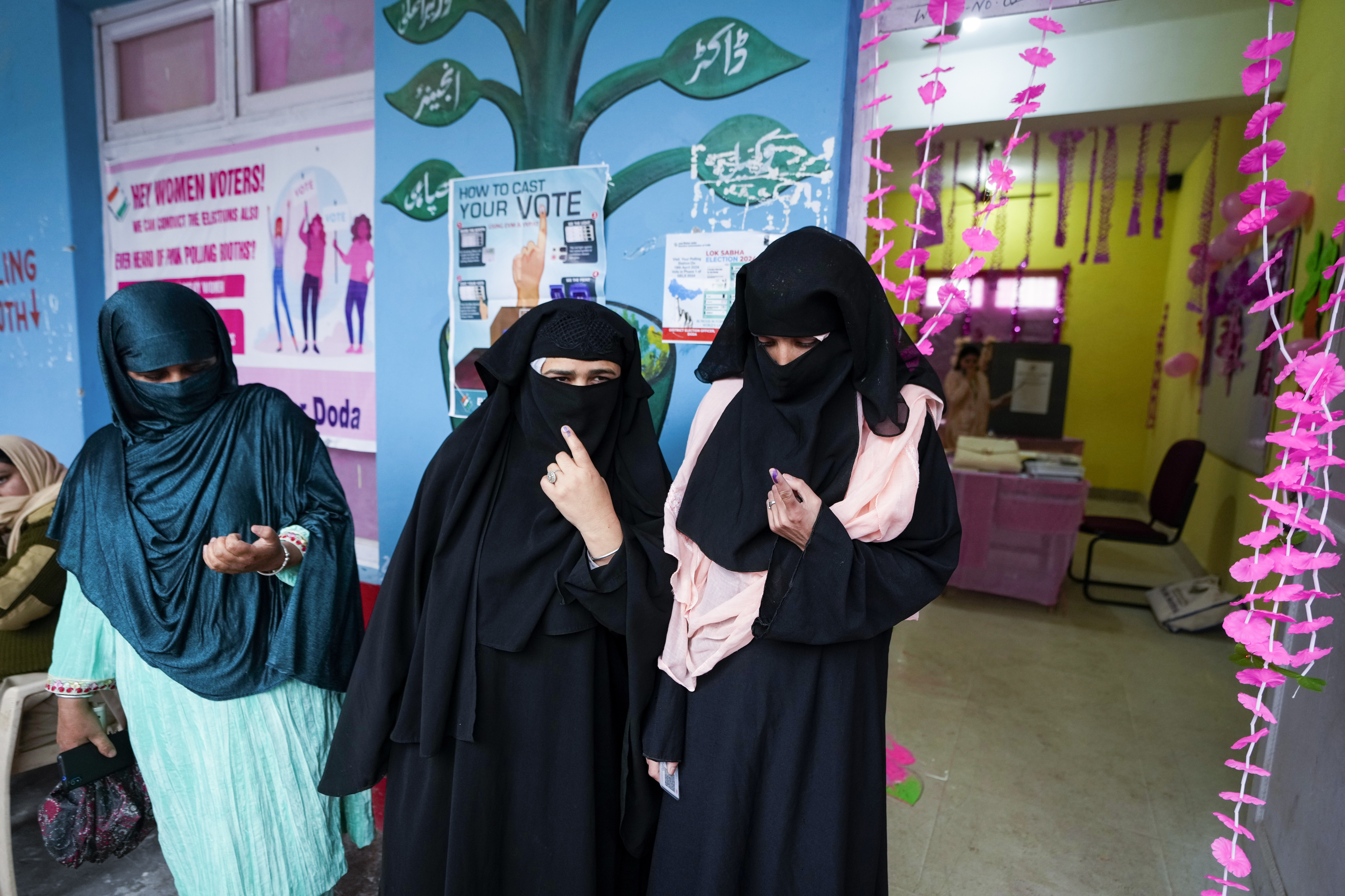 Muslim women show the indelible ink marks on their fingers after casting votes at a women only booth during the first round of polling of India’s national election in Doda district, Jammu and Kashmir