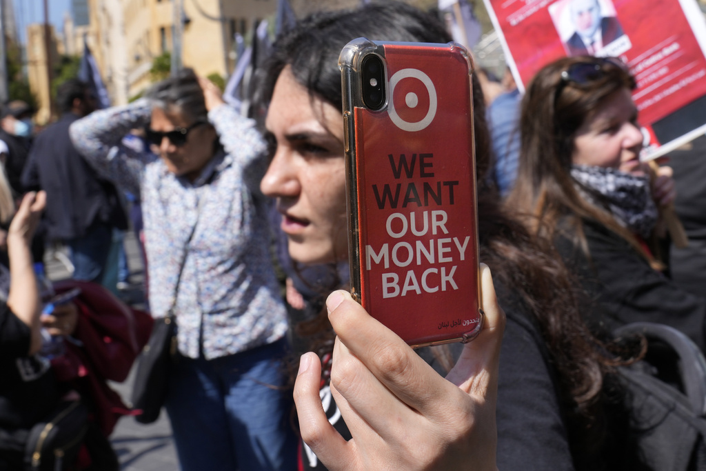 A protester depositor shows her mobile phone that she films with during a protest outside a Bank Audi branch in downtown Beirut, Lebanon