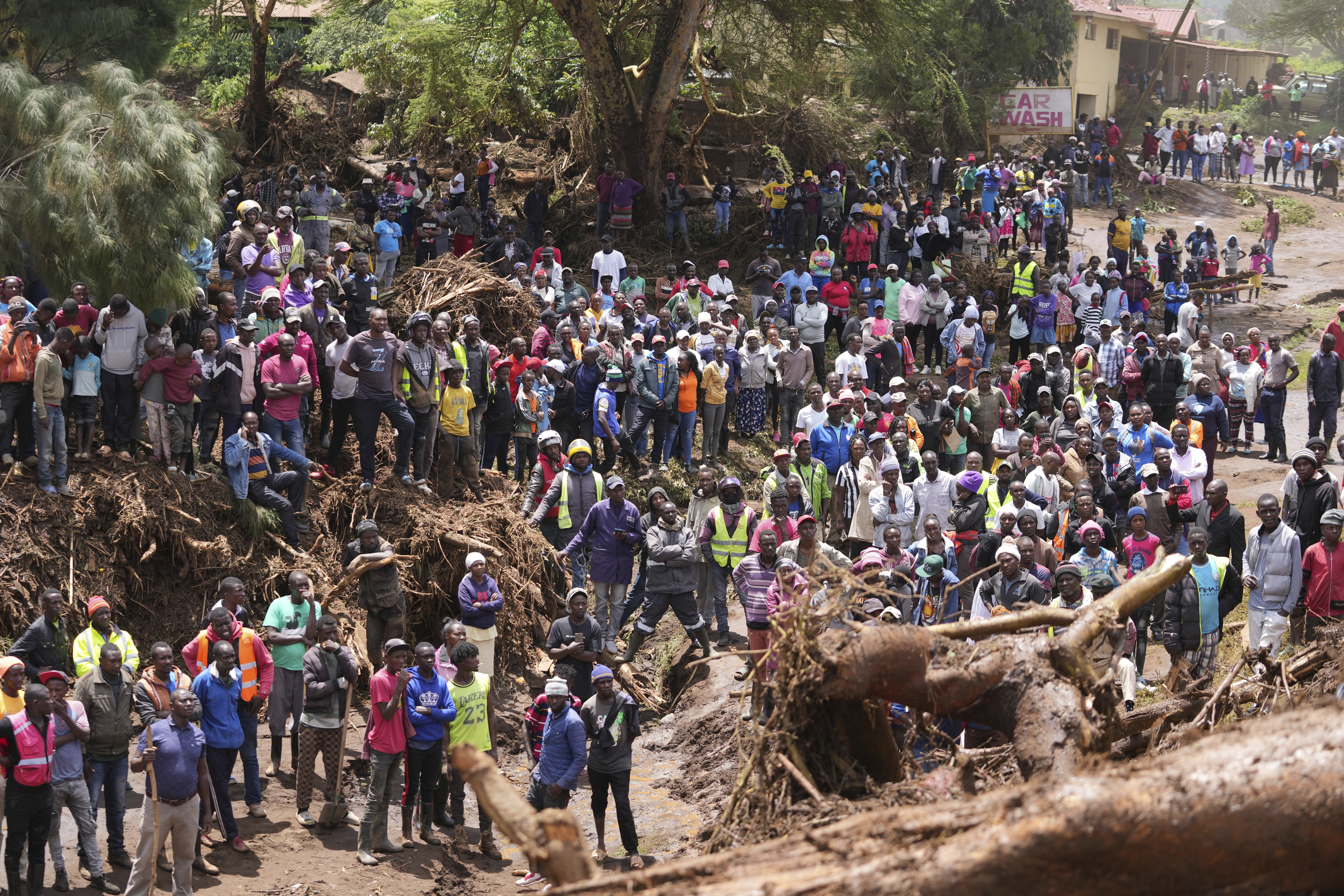 People gather on a bridge after floodwater washed away houses near Nakuru, Kenya,