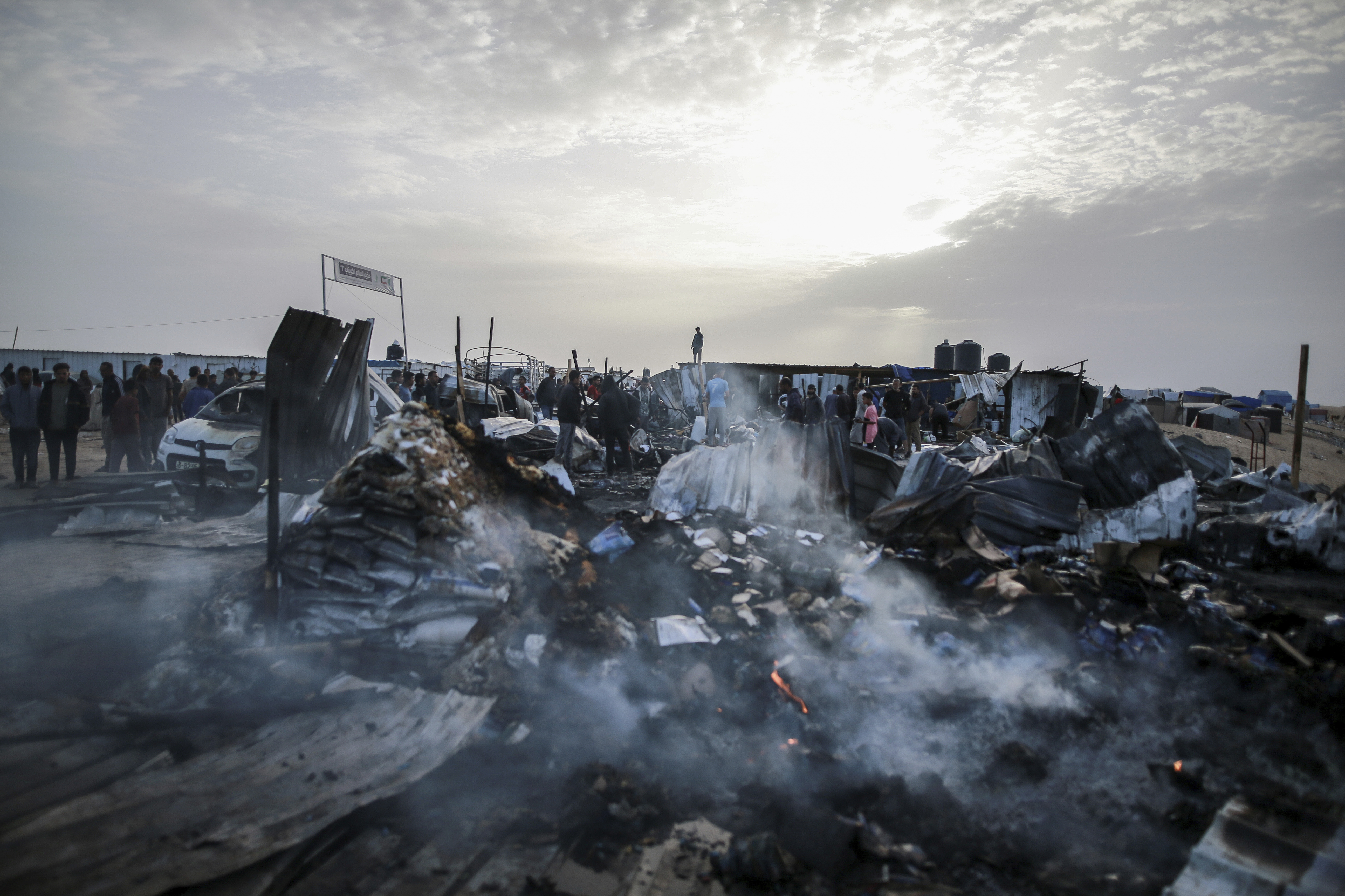 Palestinians look at the destruction after an Israeli strike where displaced people were staying in Rafah, Gaza Strip, Monday, May 27, 2024. Palestinian health workers said Israeli airstrikes killed at least 35 people in the area. Israel's army confirmed Sunday's strike and said it hit a Hamas installation and killed two senior Hamas members.