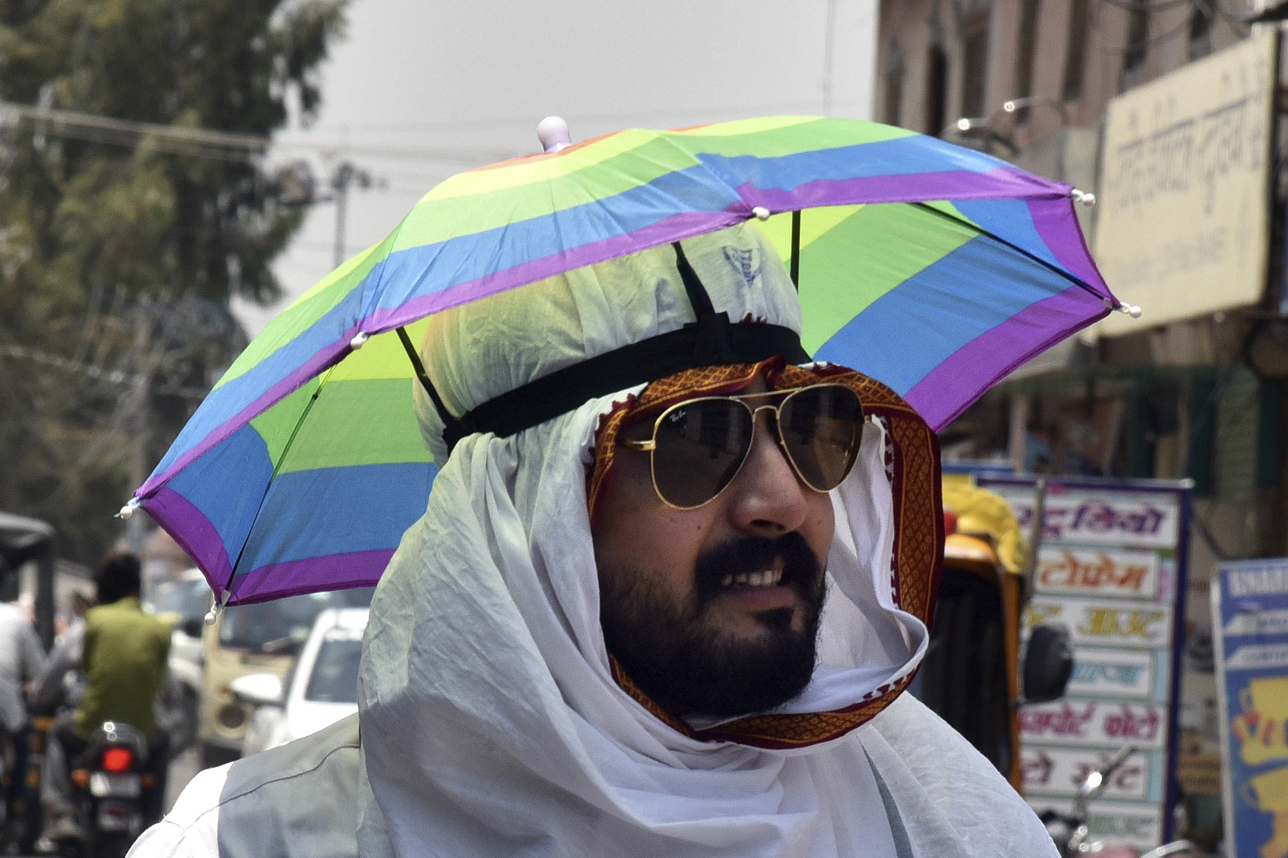 A man wears an umbrella hat on a hot summer day in Bikaner, in the Indian western state of Rajasthan