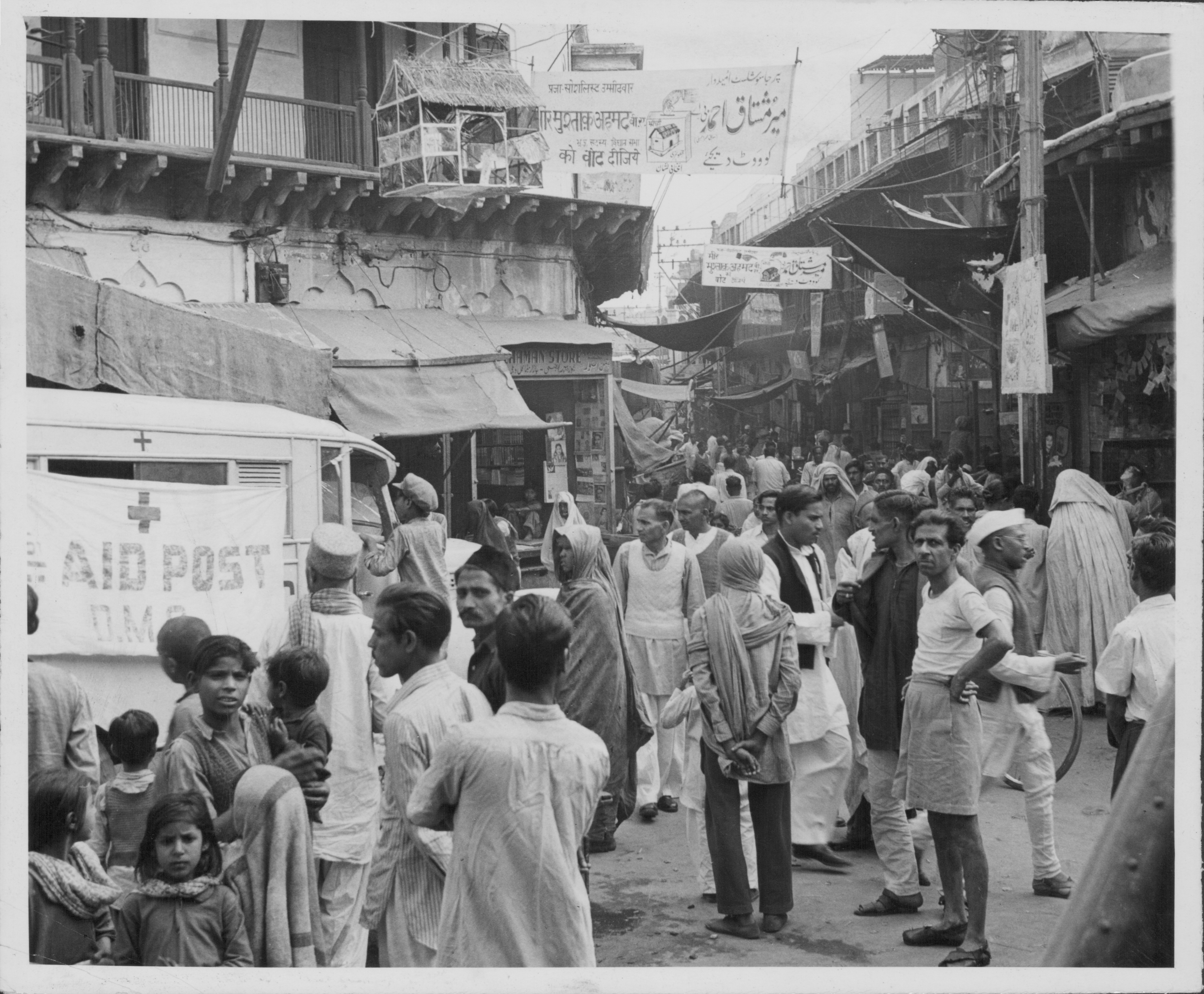 A street is filled with crowds of people for the Indian election, symbols of the Praja Socialist Party can be seen