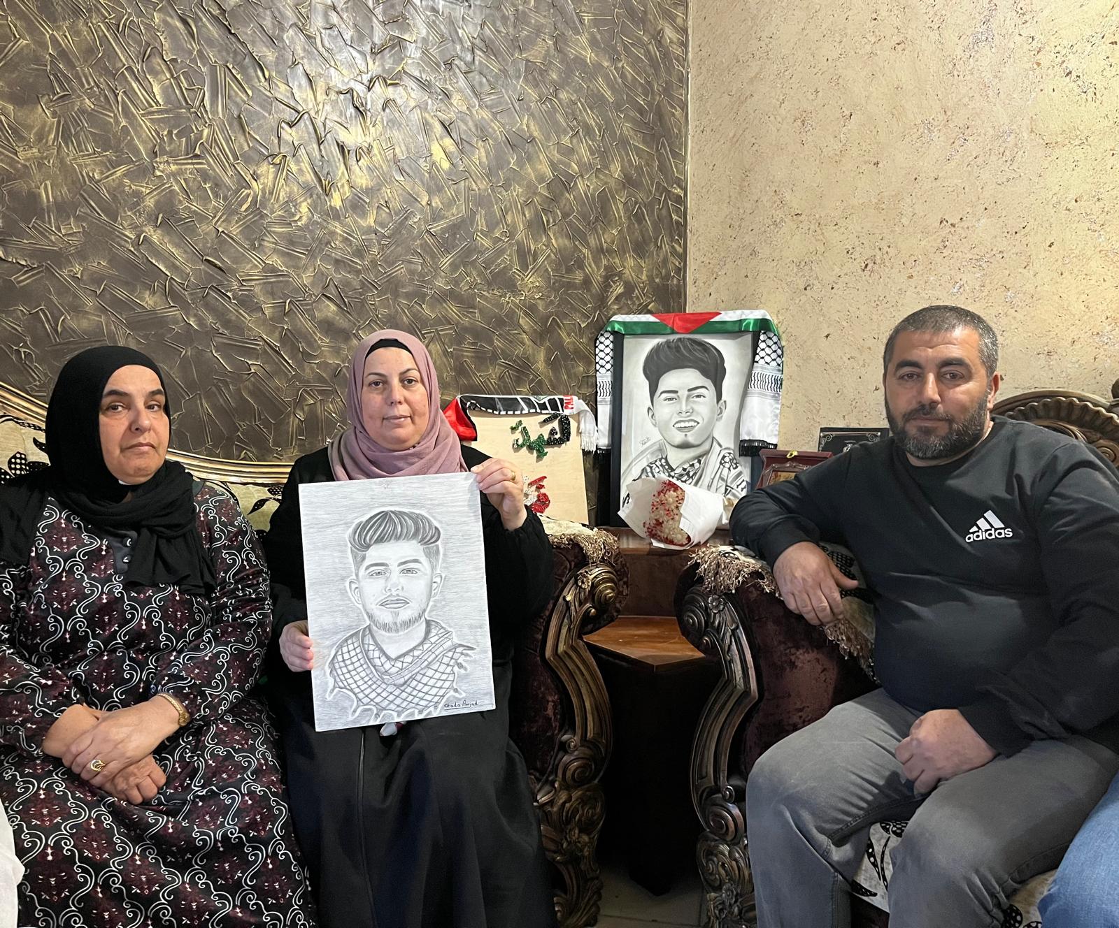 Two women and a man, with two portraits of a man