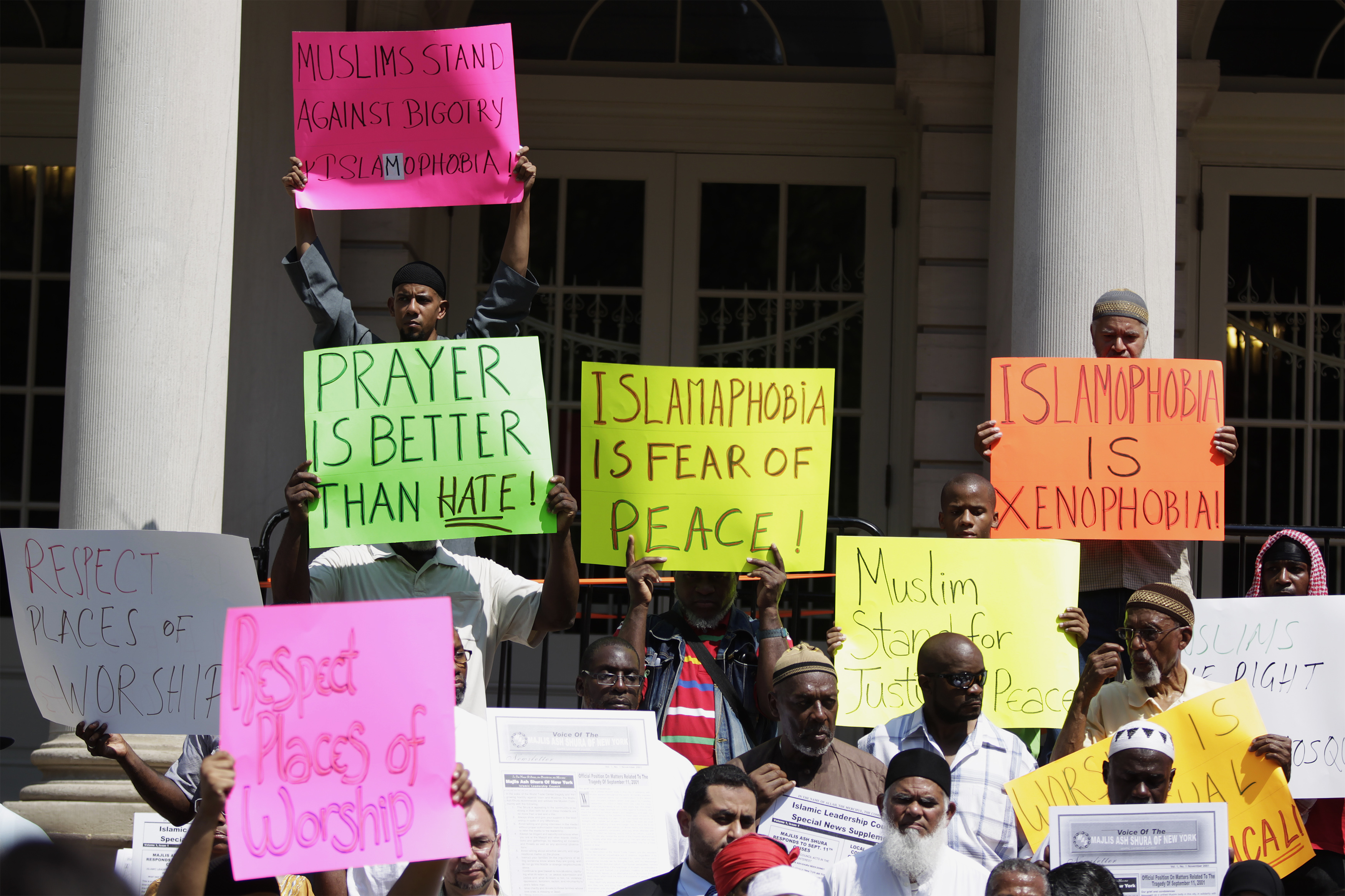 Demonstrators hold signs denouncing violence against Muslims at a news conference to issue a statement against bigotry and islamophobia at City Hall in New York