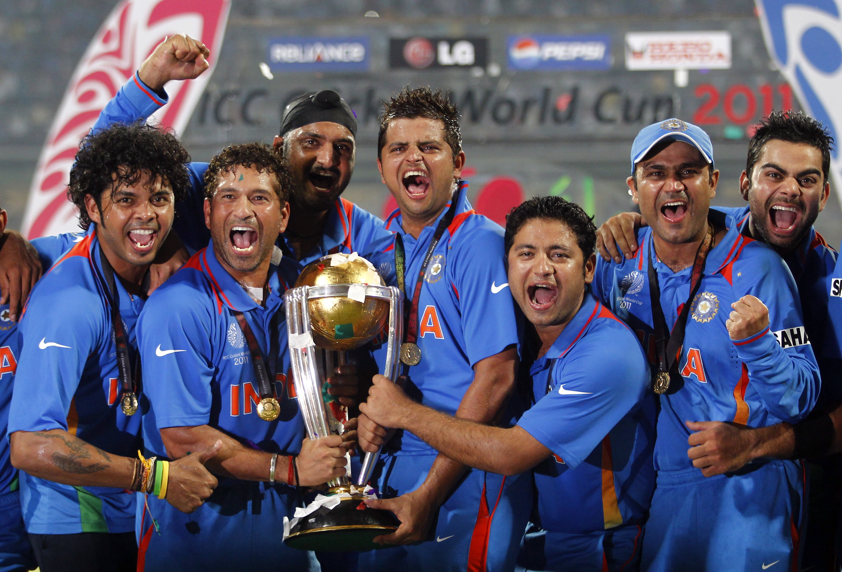 India's Shanthakumaran Sreesanth, Sachin Tendulkar, Harbhajan Singh, Suresh Raina, Piyush Chawla, Virender Sehwag and Virat Kohli (L-R) celebrate with their trophy after India won their ICC Cricket World Cup final match against Sri Lanka in Mumbai April 2, 2011. REUTERS/Adnan Abidi (INDIA - Tags: SPORT CRICKET)