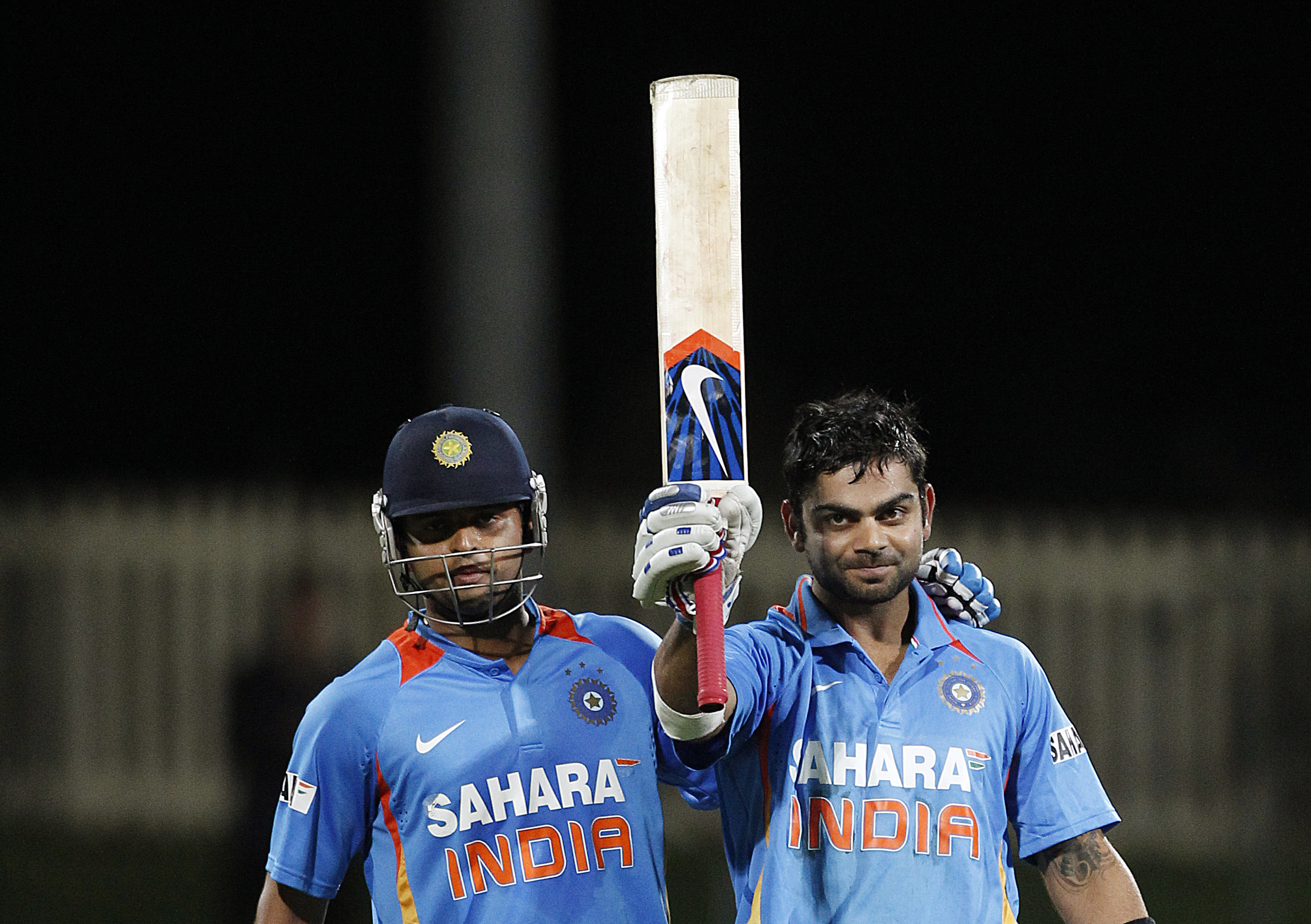 India's Suresh Raina (L) stands next to Virat Kohli as he celebrates reaching his century during their Tri-series one-day international cricket match against Sri Lanka at Bellerive Oval in Hobart February 28, 2012. REUTERS/Tim Wimborne (AUSTRALIA - Tags: SPORT CRICKET)