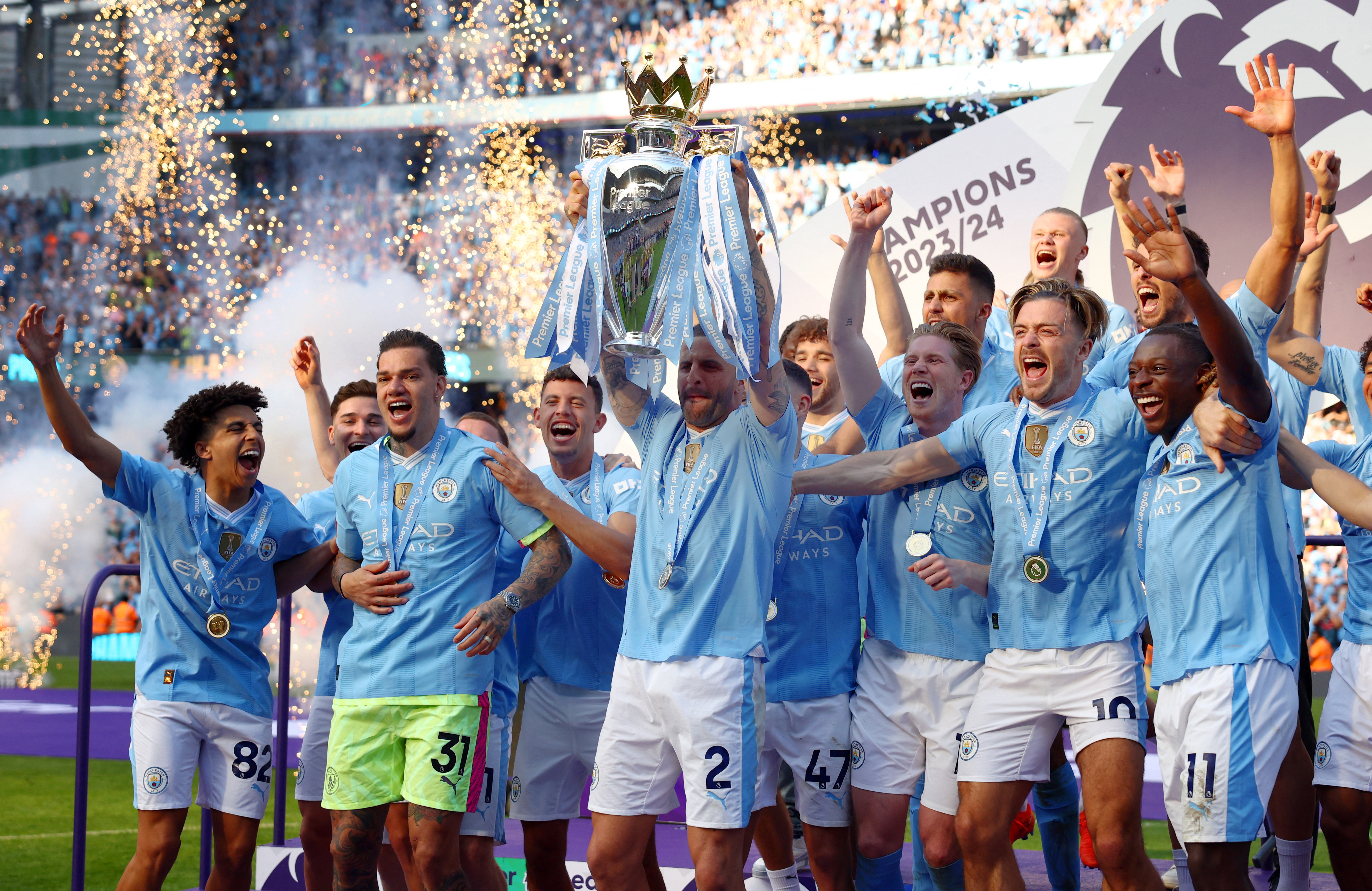 Soccer Football - Premier League - Manchester City v West Ham United - Etihad Stadium, Manchester, Britain - May 19, 2024 Manchester City's Kyle Walker lifts the trophy on the podium and celebrates with teammates after winning the Premier League Action Images via Reuters/Lee Smith
