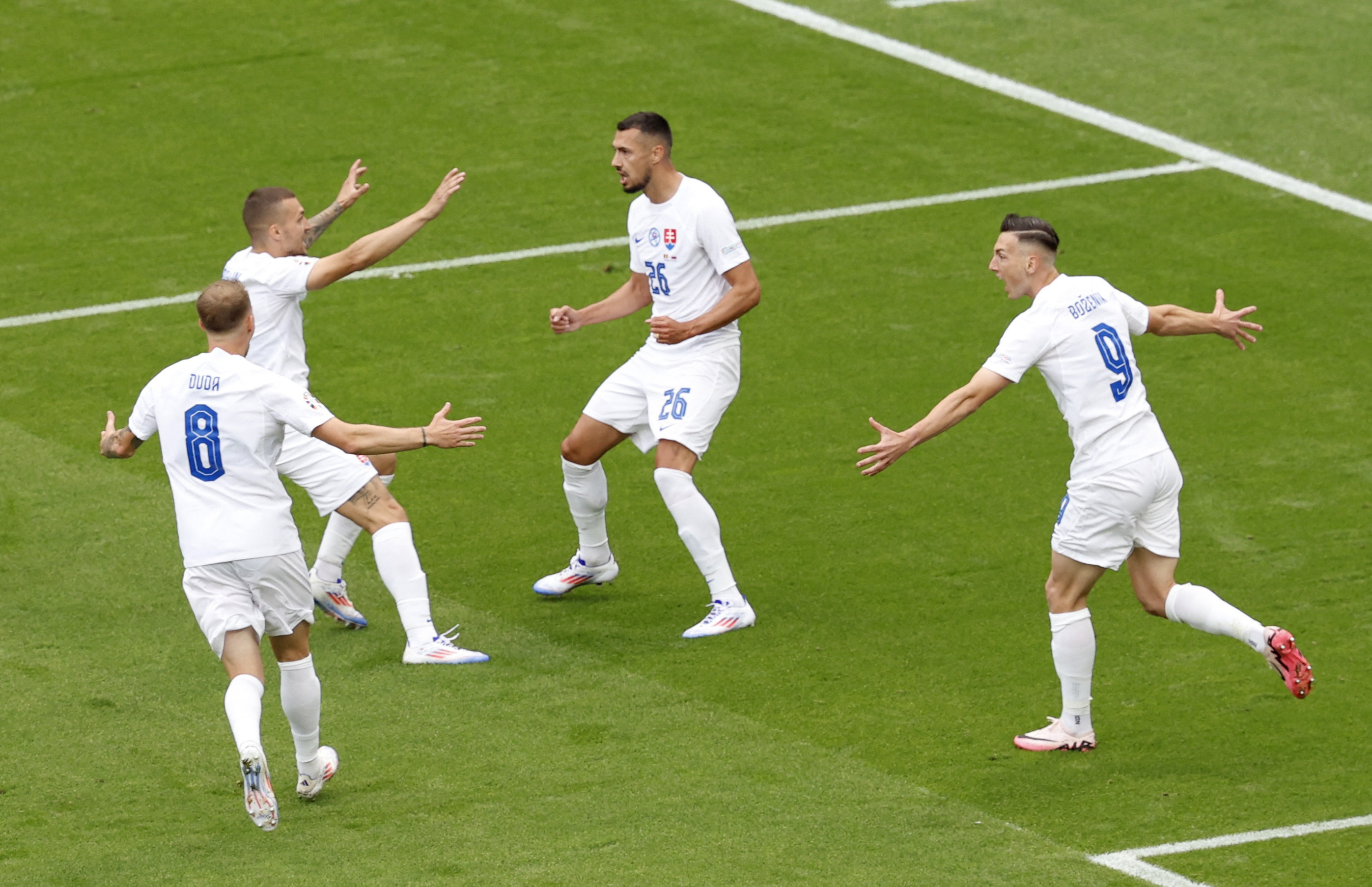 Football players celebrate goal.