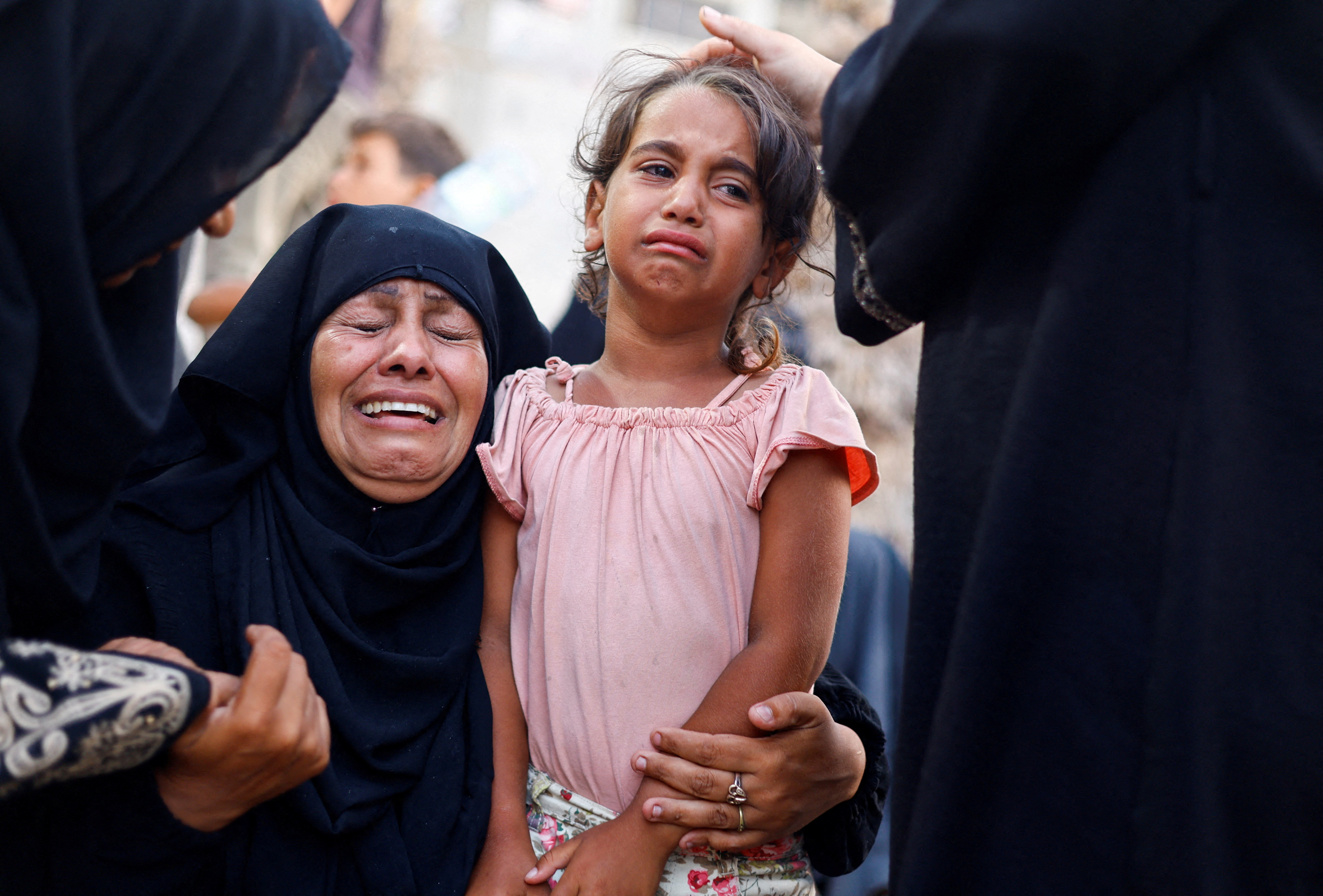 A woman and a girl react following an Israeli strike that hit a tent camp, amid the ongoing conflict between Israel and Hamas, in Al-Mawasi area in western Rafah, in the southern Gaza Strip