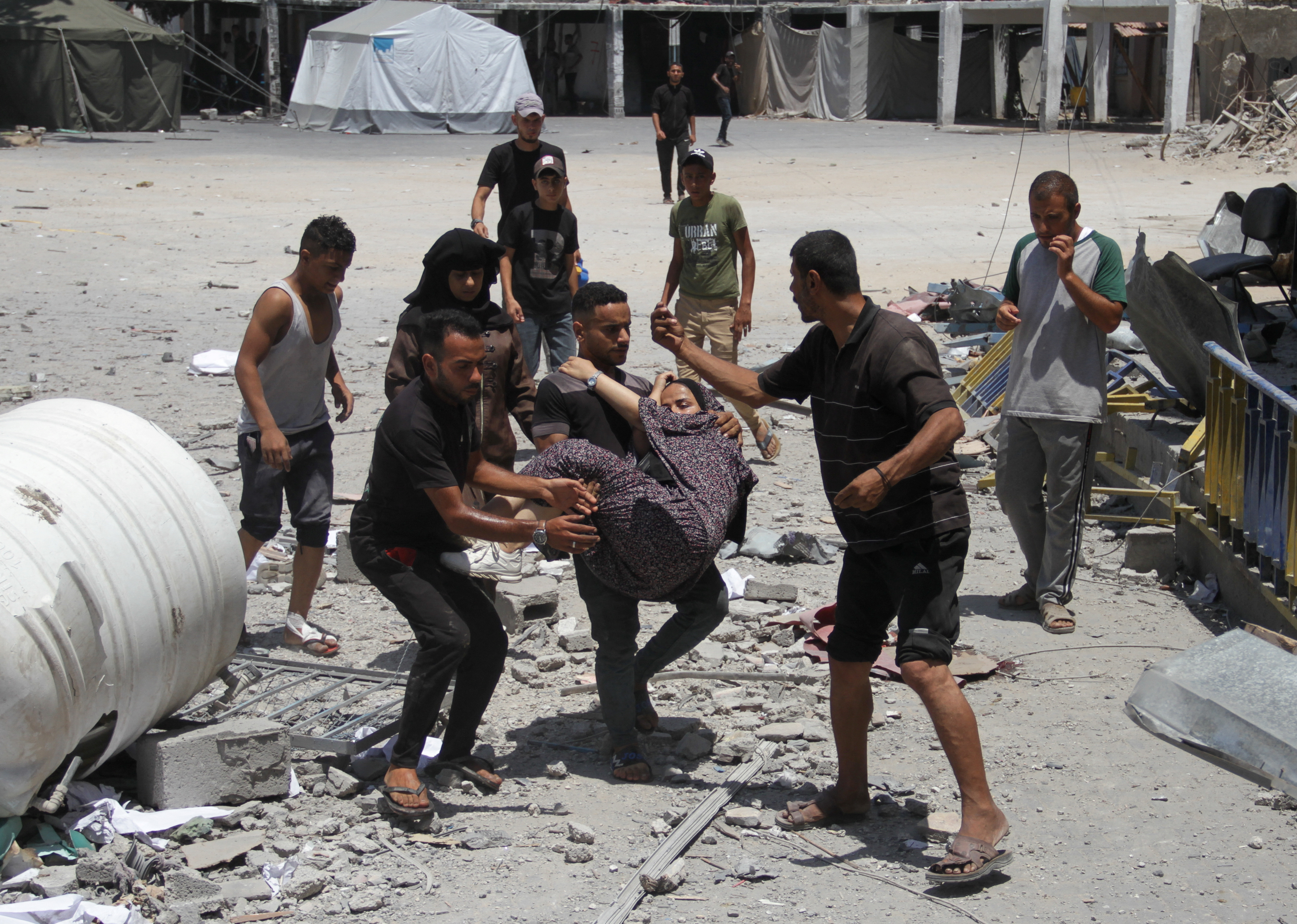 Palestinians carry a wounded outside the UNRWA headquarters following an Israeli attack in Gaza City,