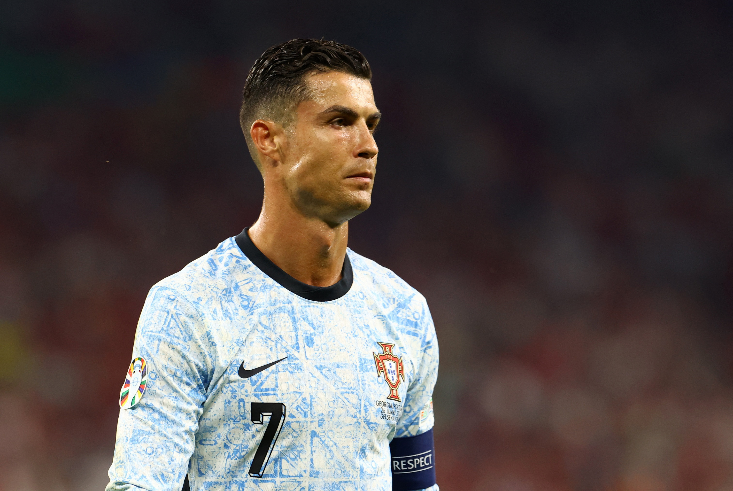 Footballer walking on playing field.