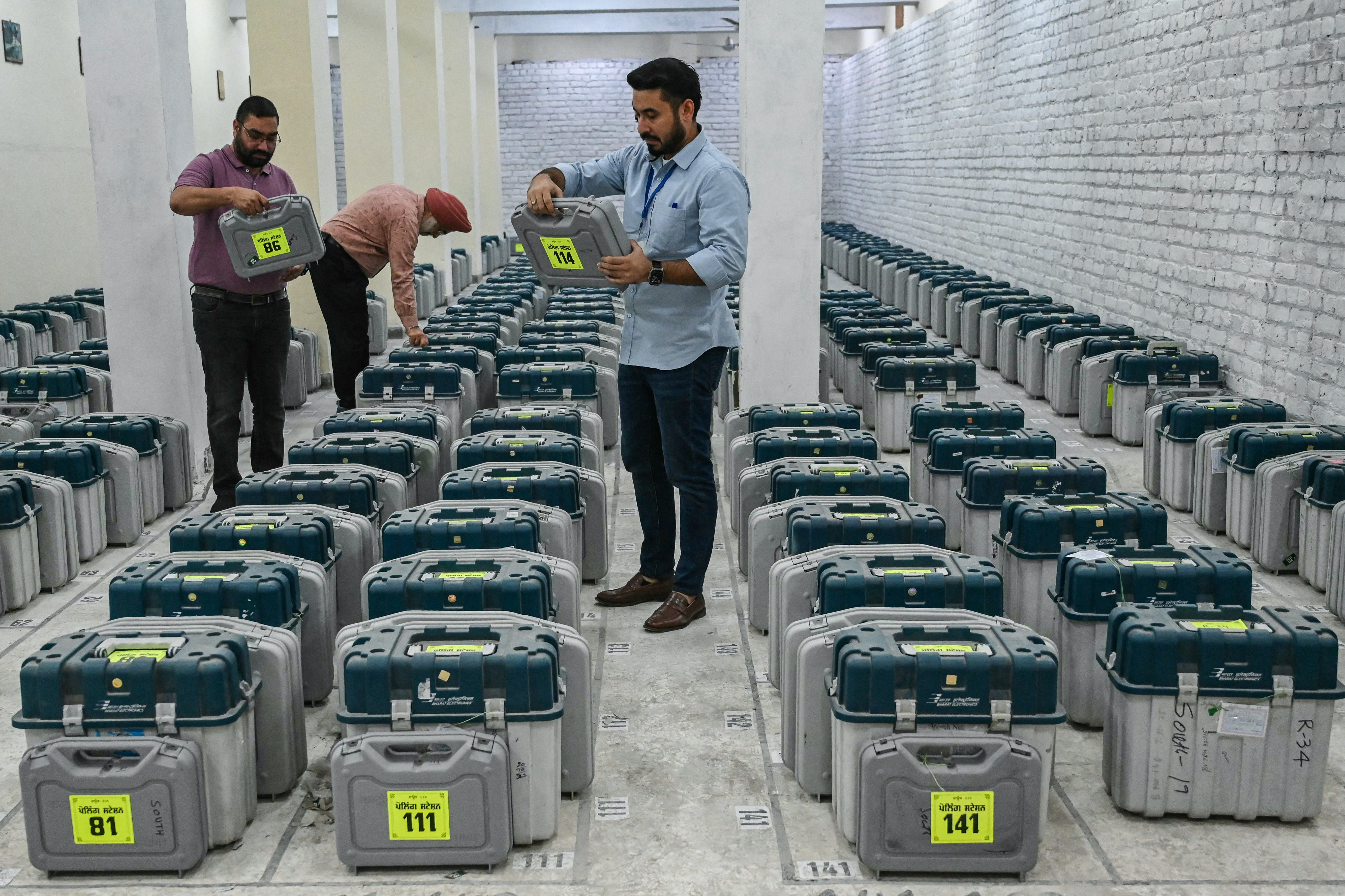 Election officials check Electronic Voting Machines (EVMs) and Voter Verifiable Paper Audit Trail (VVPAT) kept at a strong room inside a distribution center in Amritsar on May 31