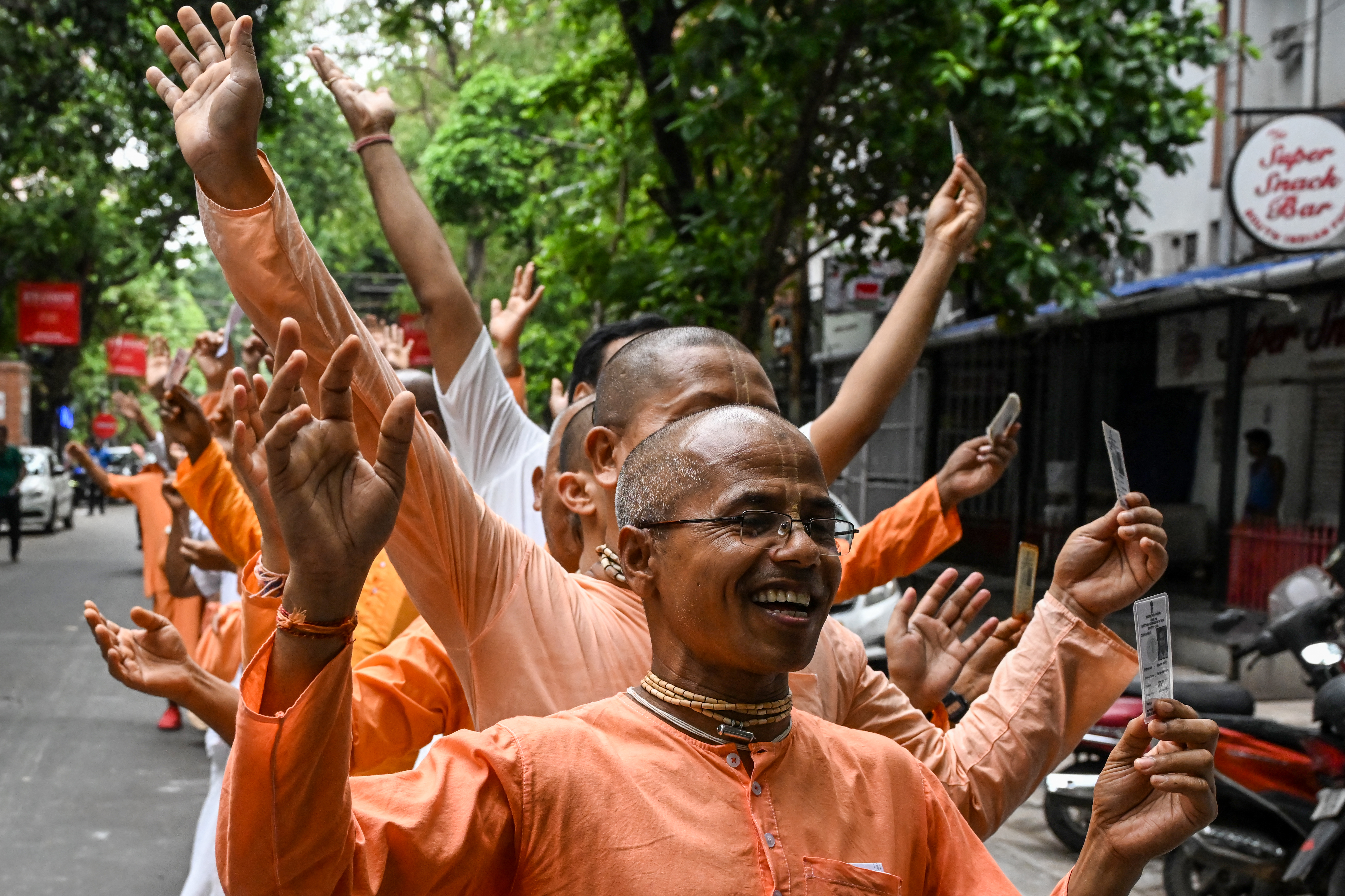 Monks stand in a queue to cast their ballot at a polling station on the seventh and final phase of voting in India's general election, in Kolkata on June 1