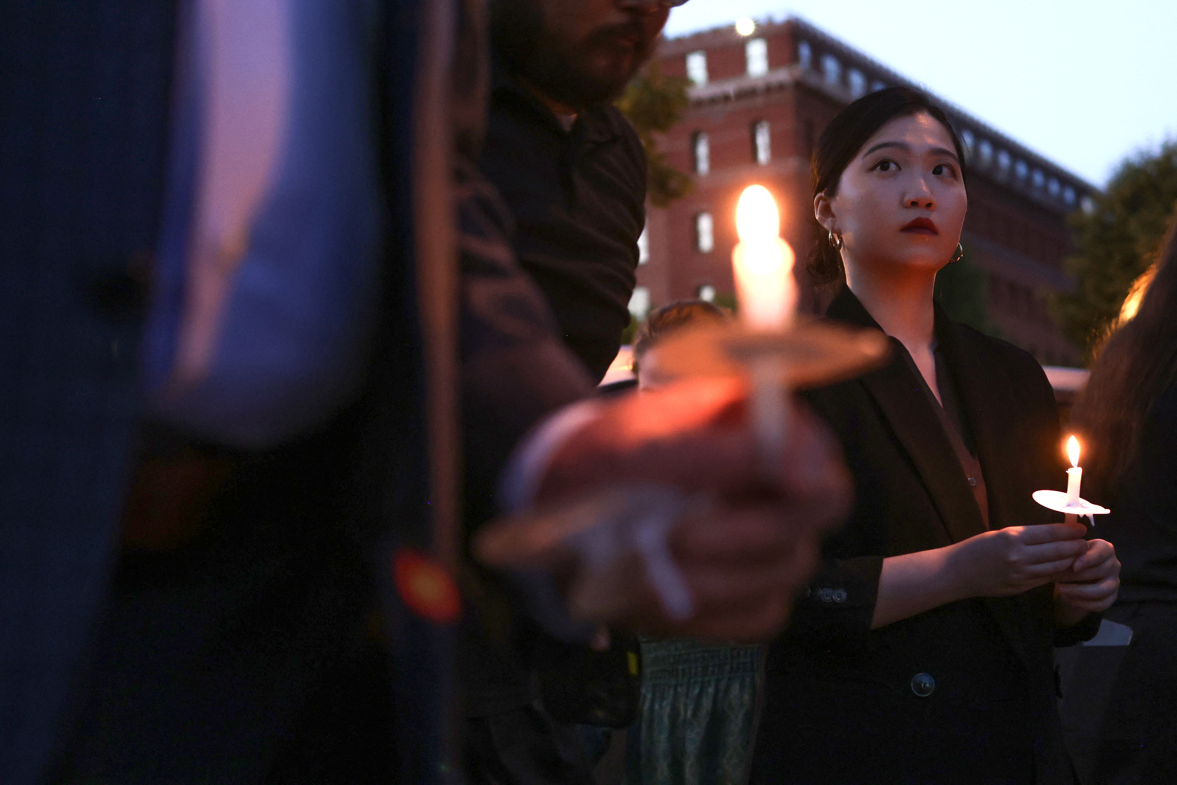 Hong Kong Democracy Council Executive Director Anna Kwok holds a candle as she participates during a candlelight vigil 