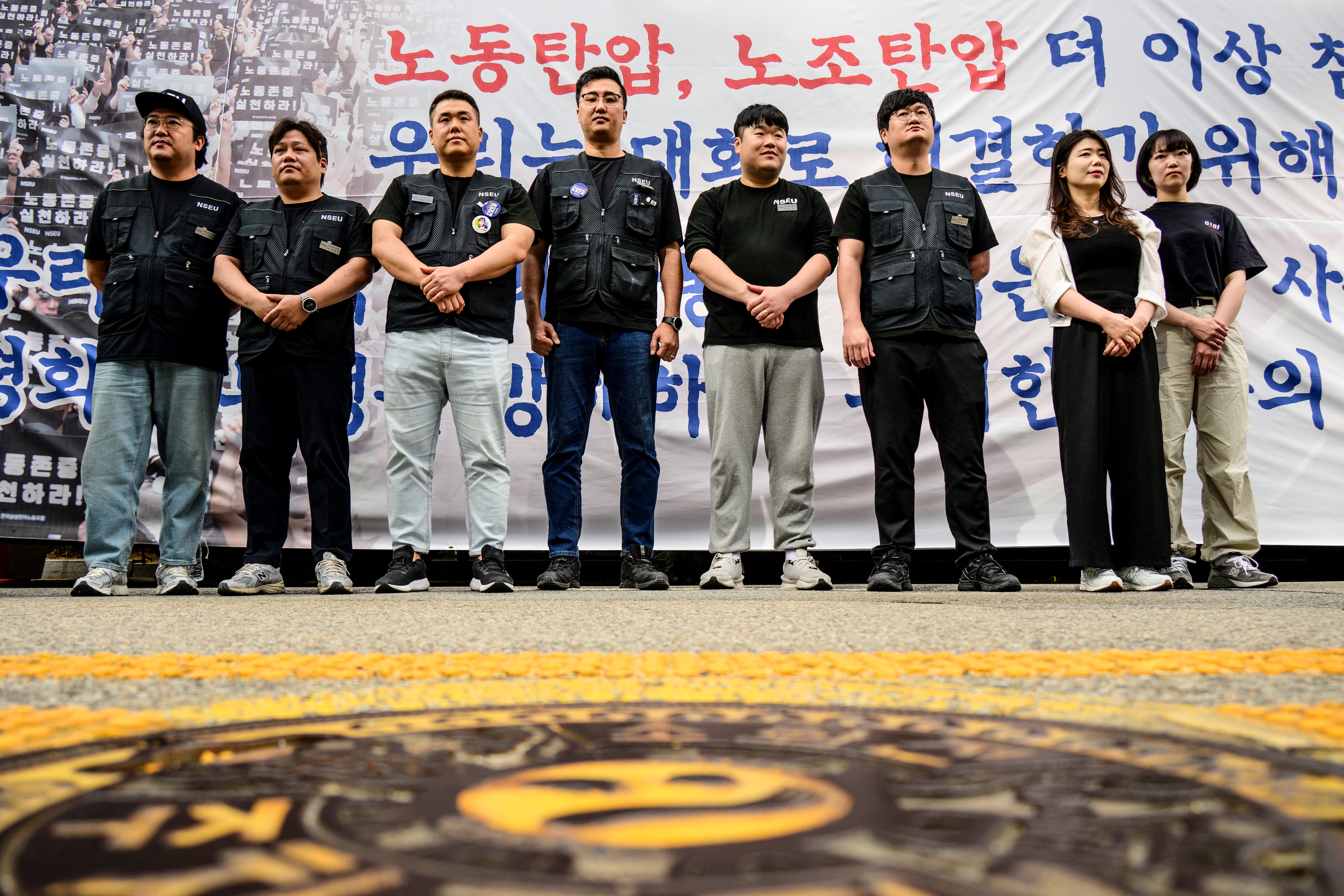 A group of South Koreans standing outside the compnay's headquarters.