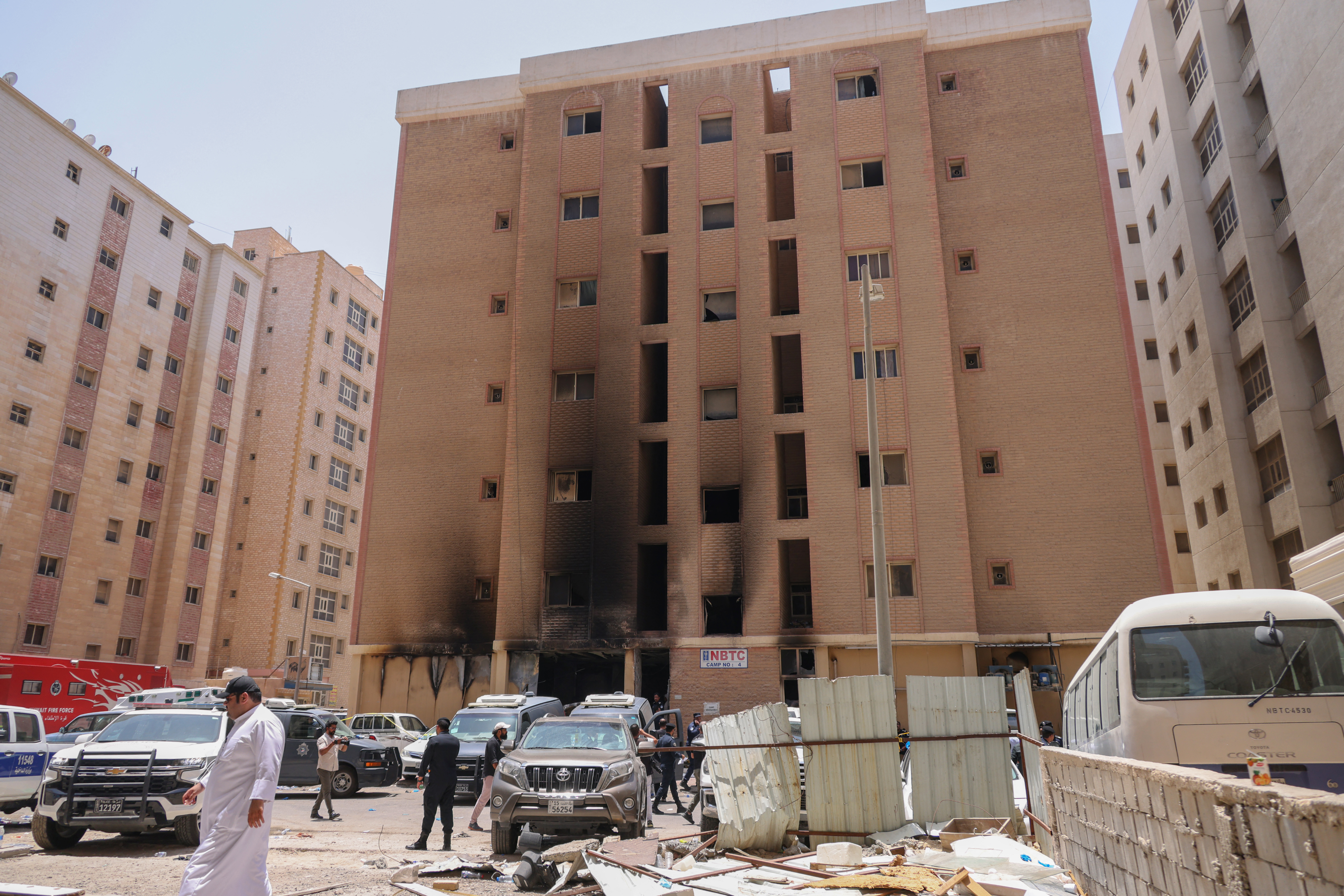 People walk past a building which was ingulfed by fire, in Kuwait City