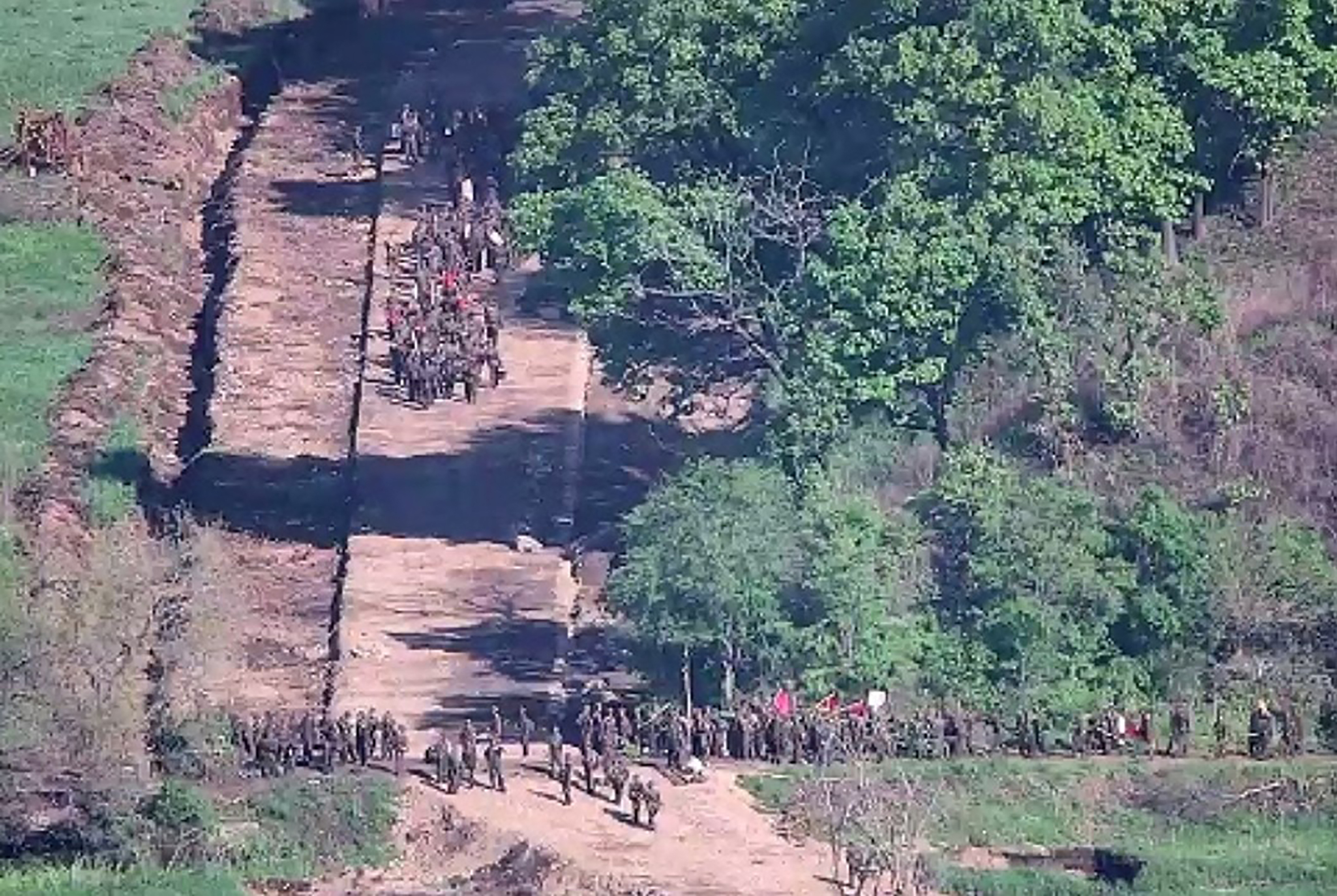 North Korean soldiers at a location near the border in an aerial photo. They are lined up on what seems like a road.