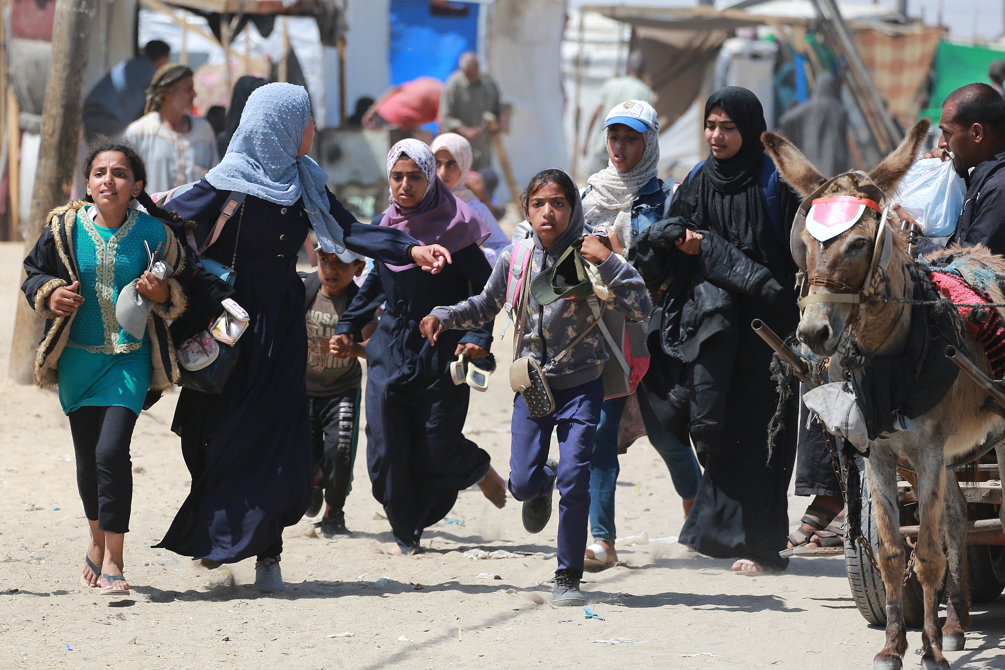 Palestinians rush during Israeli bombardment in the area in Rafah in the southern Gaza Strip on June 19, 2024