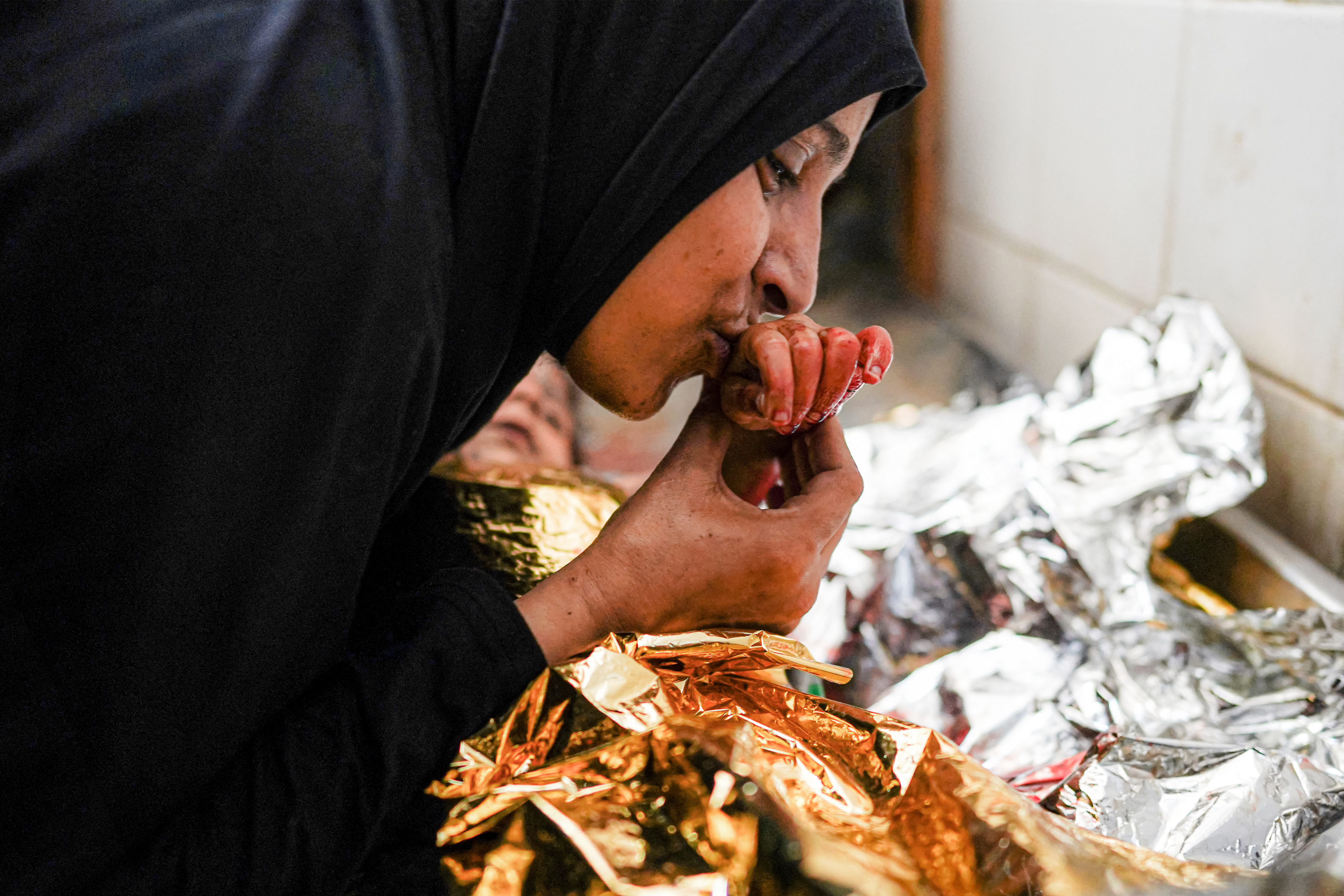 A mother bids farewell to the body of her child who was killed in the aftermath of overnight Israeli bombardment in al-Maghazi in the central Gaza Strip, at the morgue of the Aqsa Martyrs hospital in Deir el-Balah on June 25