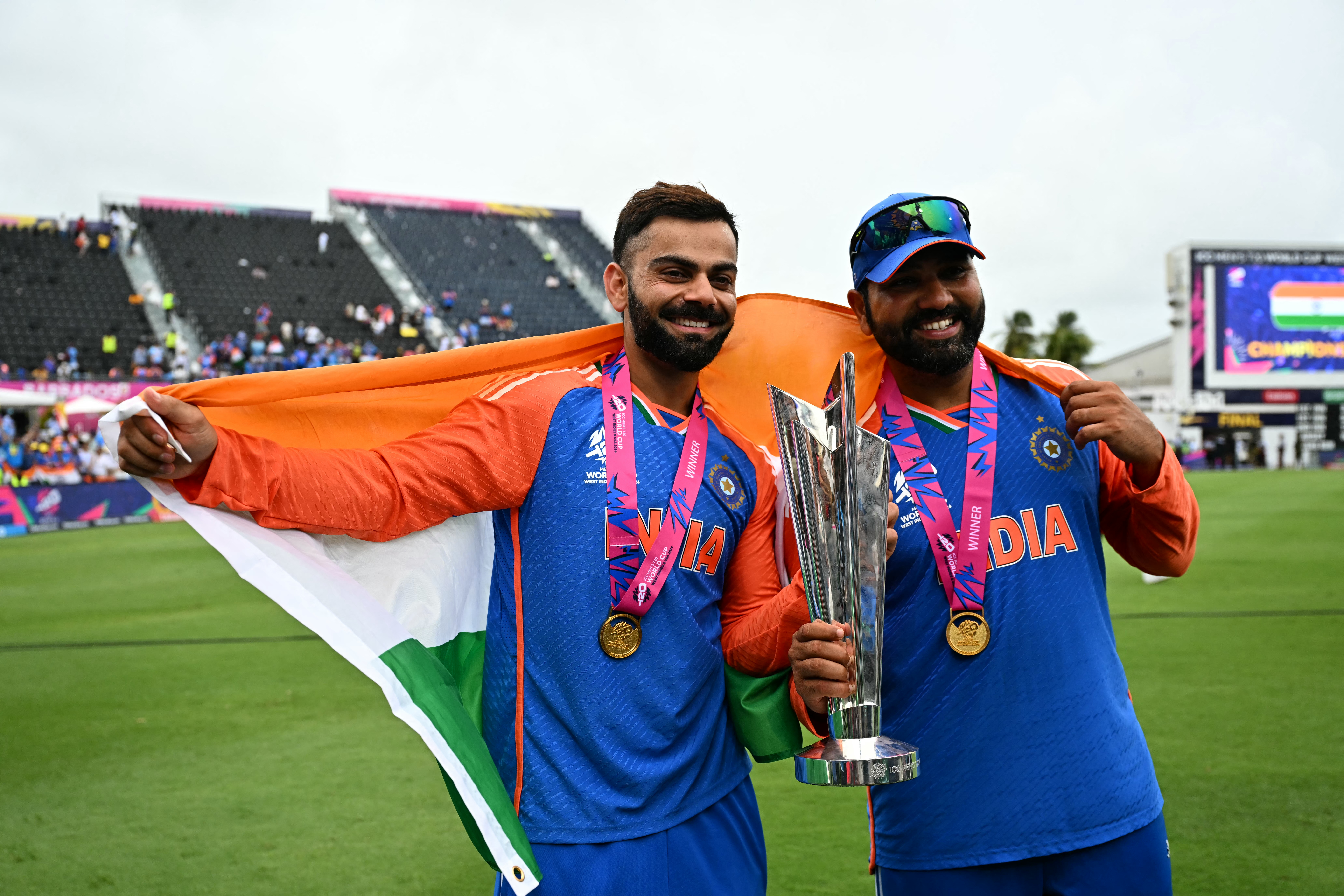India's Virat Kohli and captain Rohit Sharma celebrate with the trophy after winning the ICC men's Twenty20 World Cup 2024 final cricket match between India and South Africa at Kensington Oval in Bridgetown, Barbados, on June 29, 2024. (Photo by CHANDAN KHANNA / AFP)