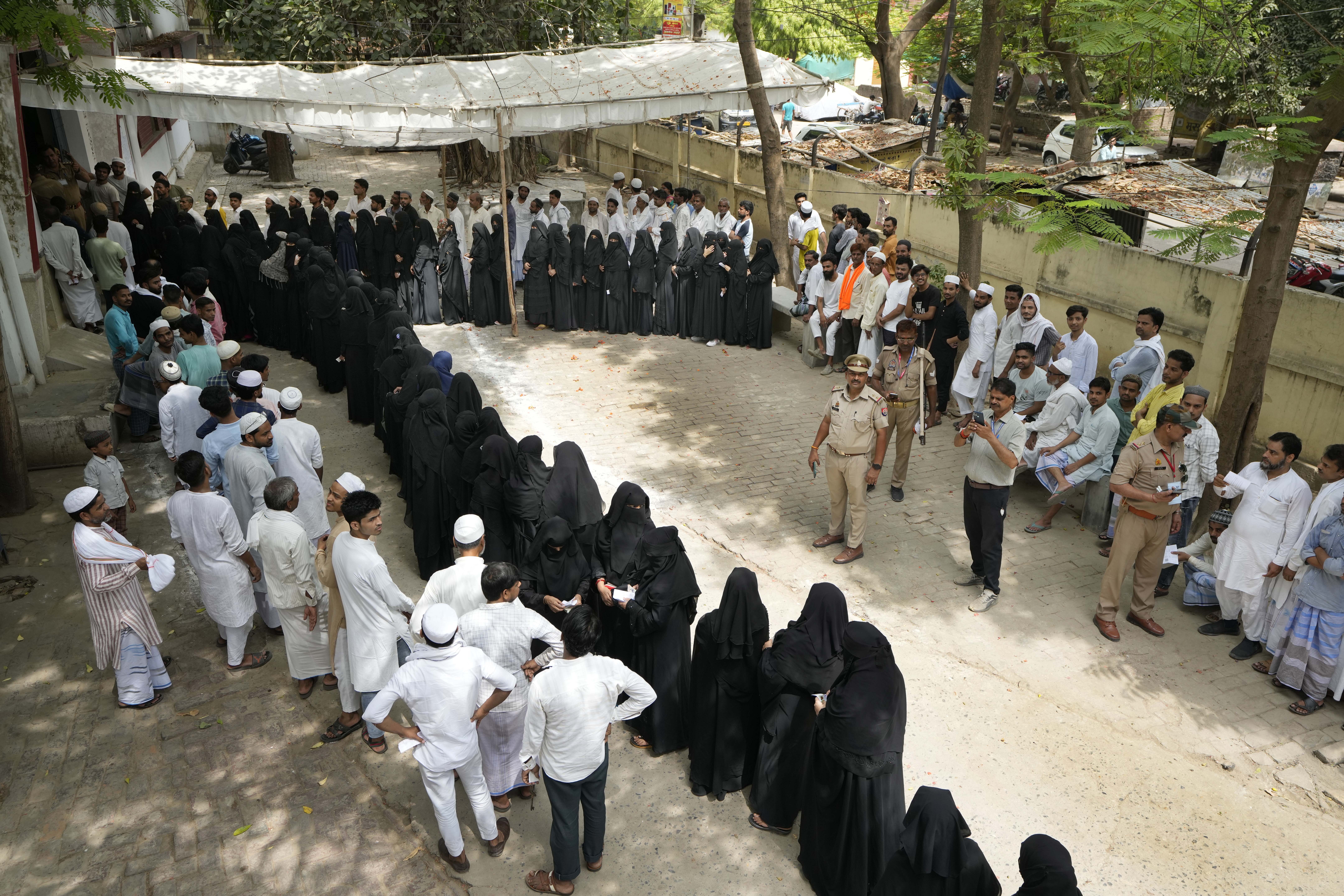 People stand in queues to cast their votes in the seventh and final phase of national elections, in Varanasi, India, Saturday, June 1
