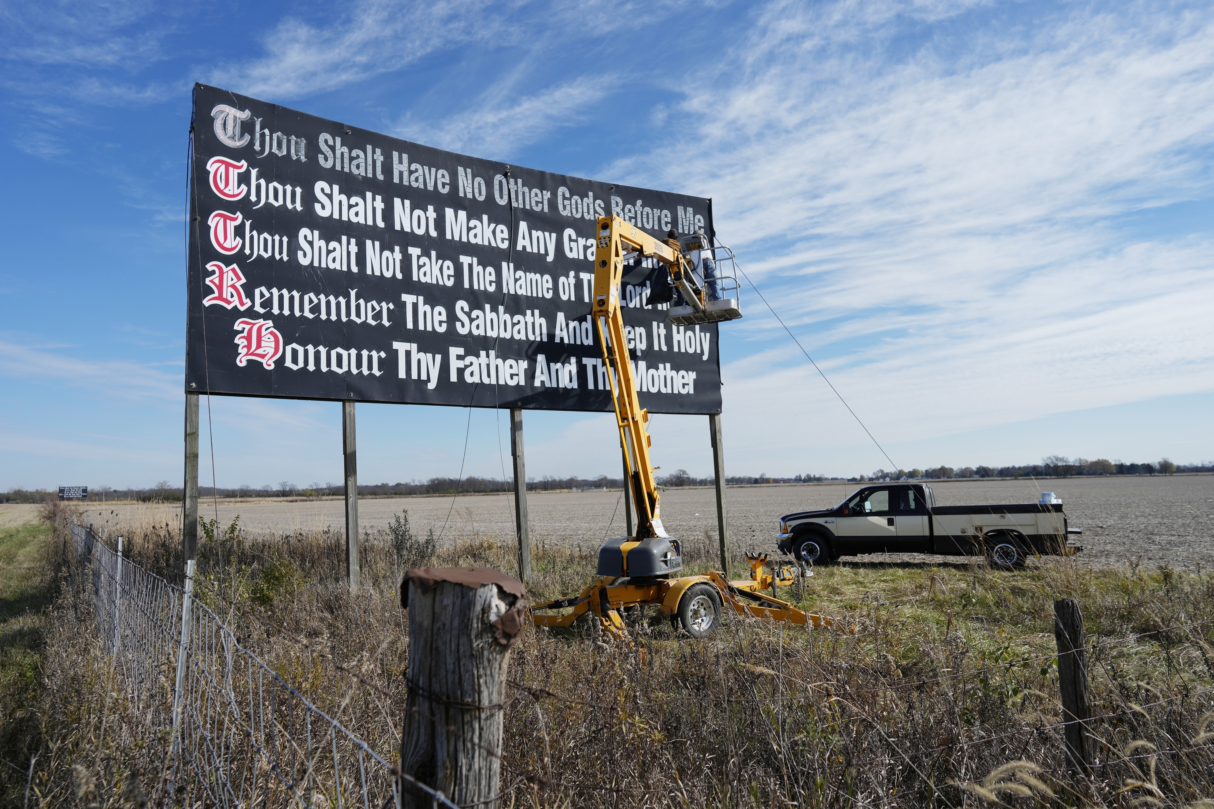 Workers repaint a Ten Commandments billboard off of Interstate 71 on Election Day near Chenoweth, Ohio