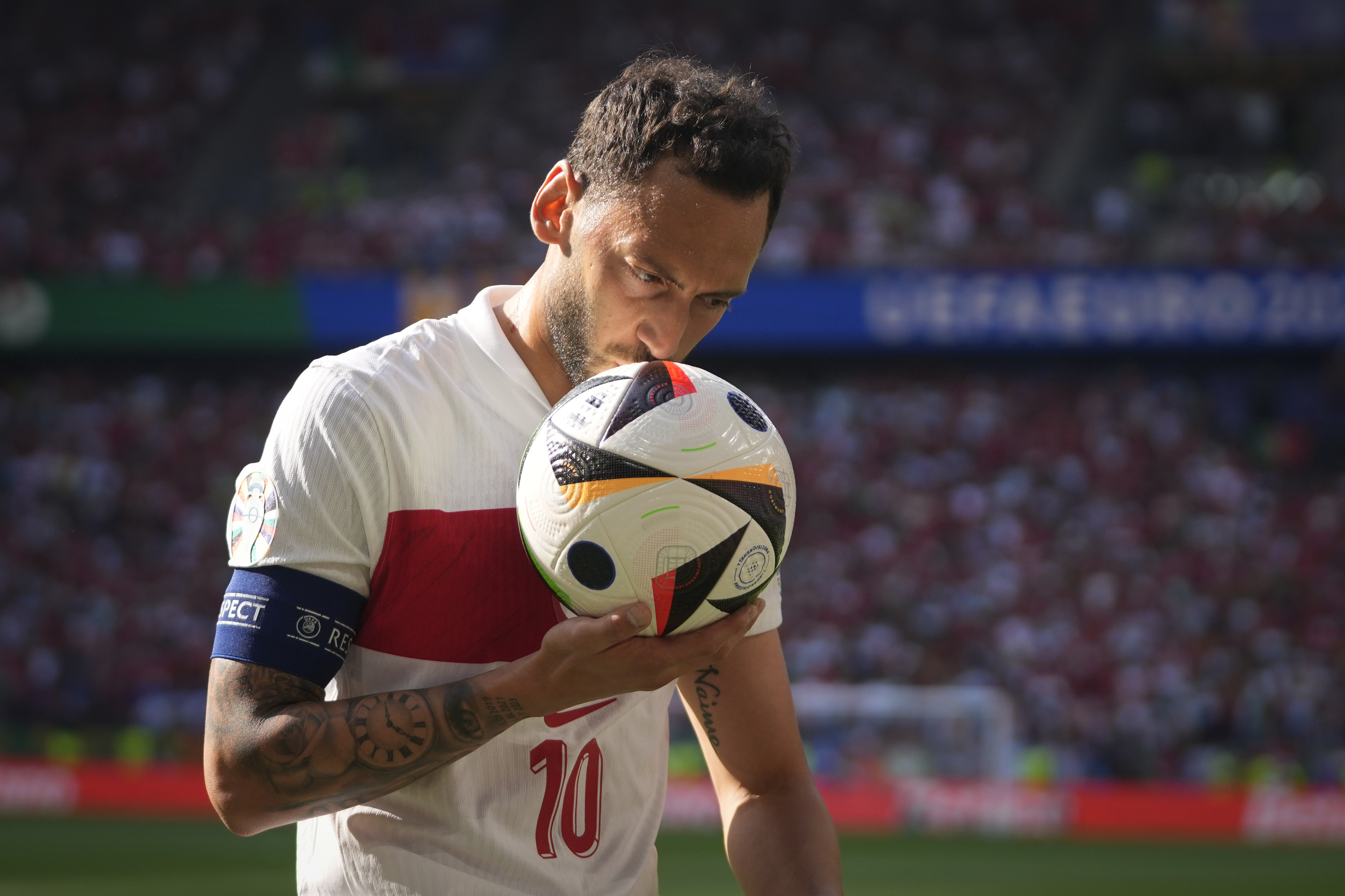 Football plyer puts ball towards his head.