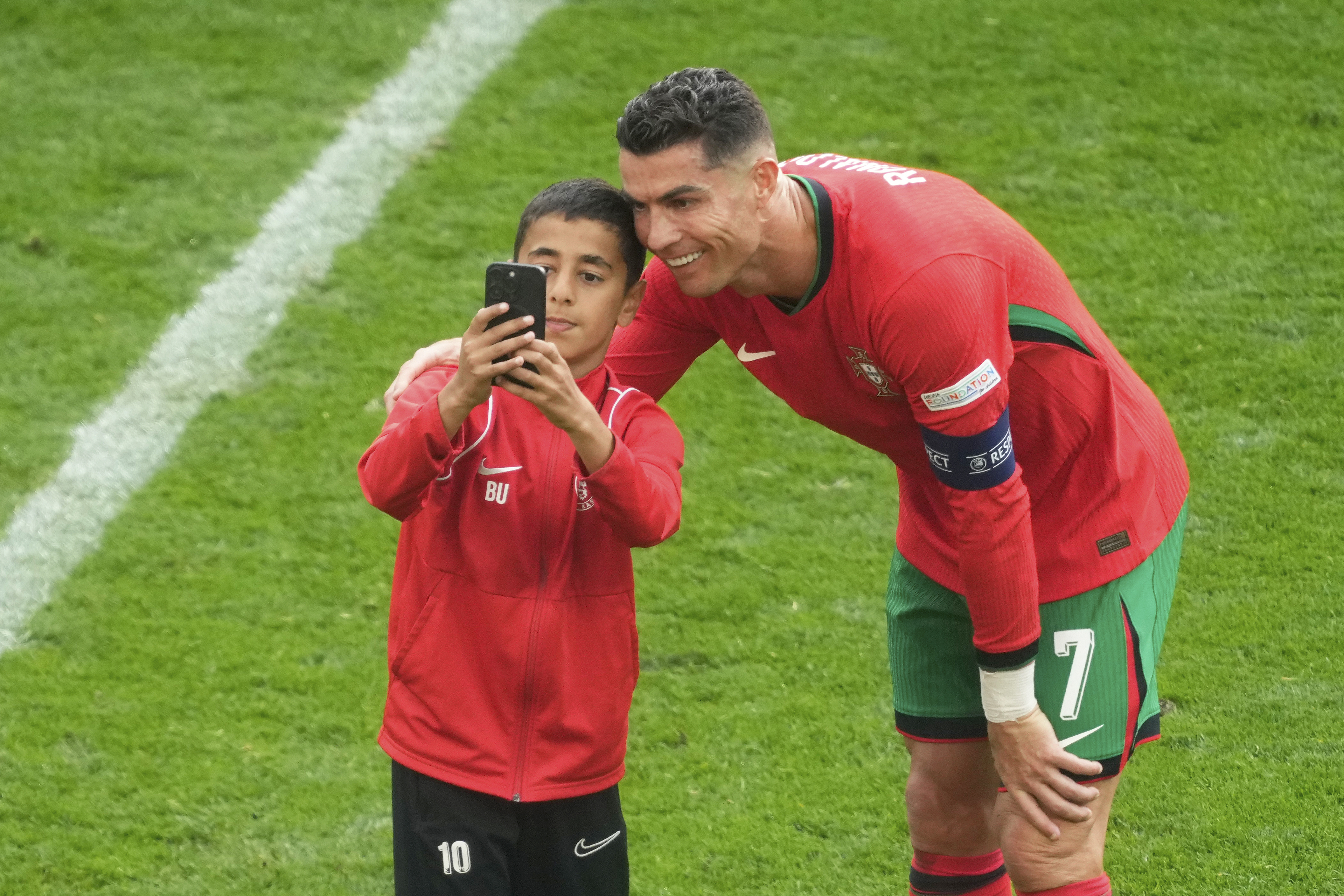 A young pitch invader takes a selfie with Cristiano Ronaldo during Portugal's Group F match against Turkey at Euro 2024 in Dortmund, Germany