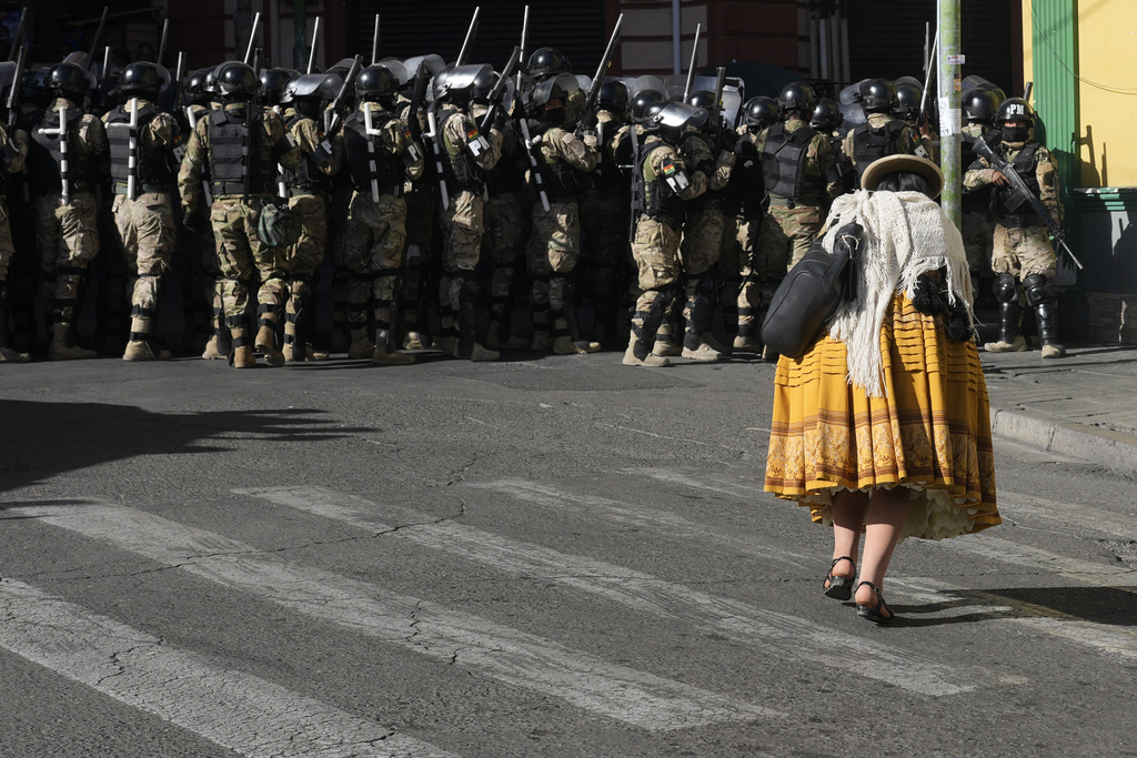 A woman walks past a group of heavily armed police