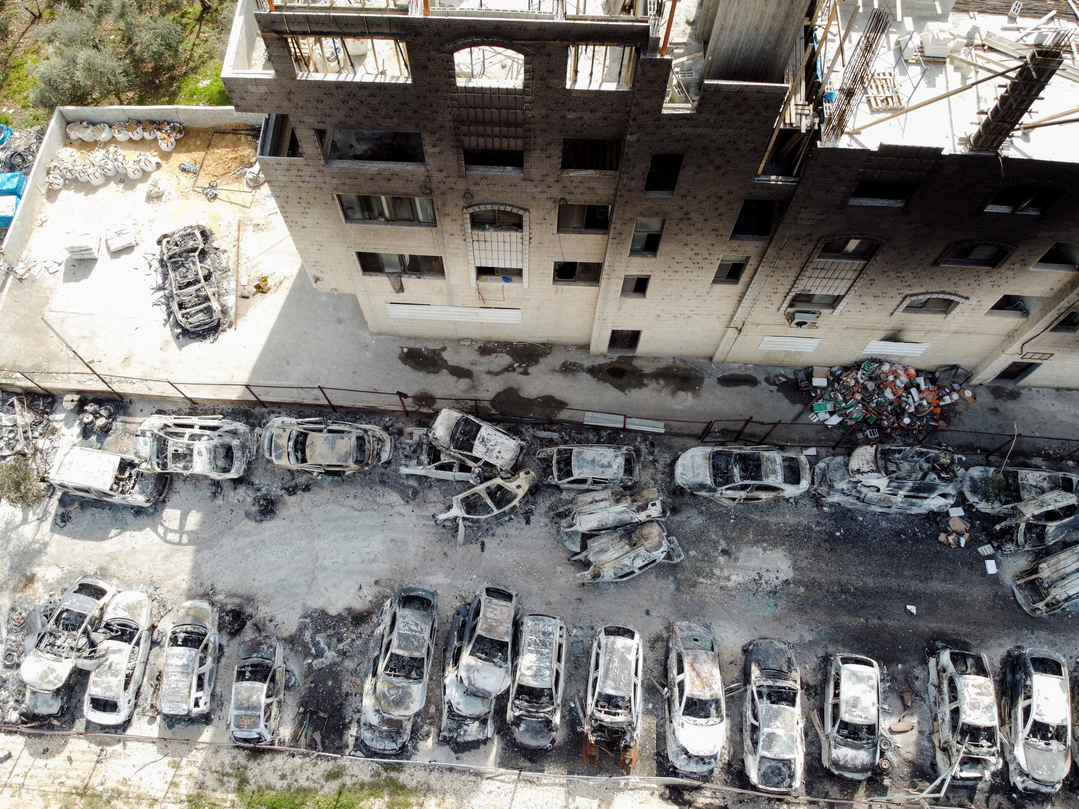 An aerial view shows a building and cars burnt in an attack by Israeli settlers