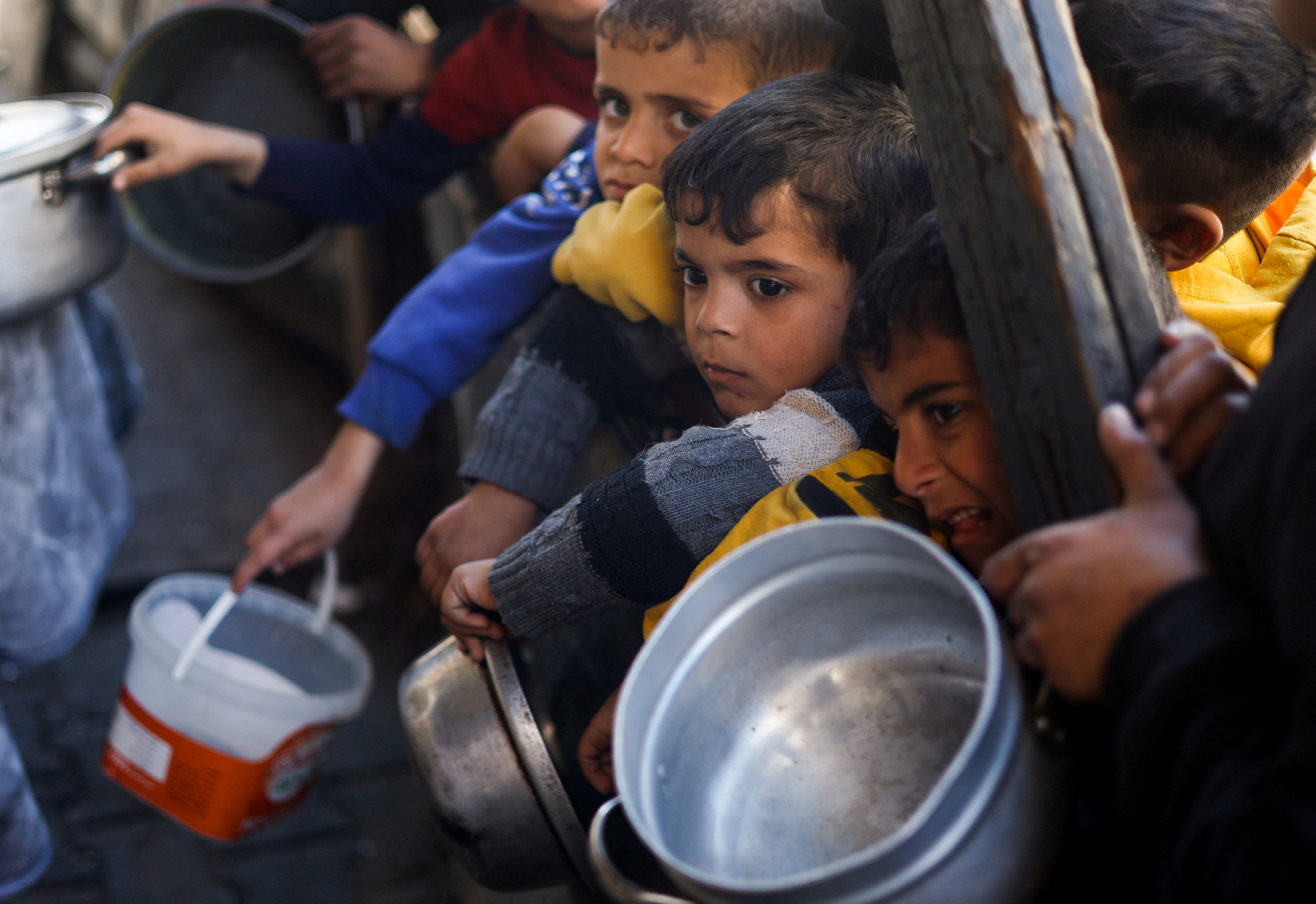 Palestinian children wait to receive food cooked by a charity kitchen amid shortages of food supplies, as the ongoing conflict between Israel and the Palestinian Islamist group Hamas continues, in Rafah, in the southern Gaza Strip, March 5, 2024. REUTERS/Mohammed Salem