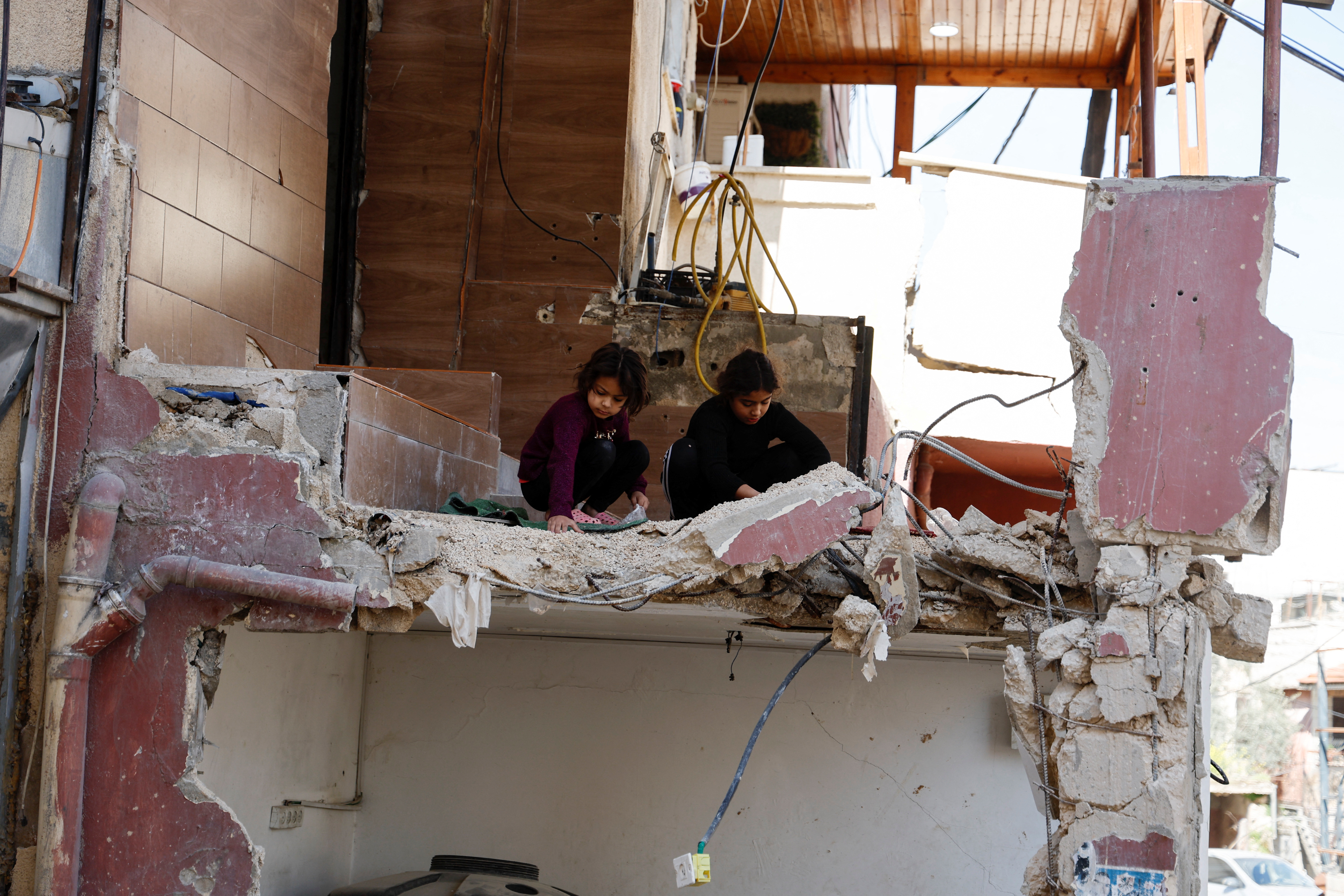 Palestinian children inspect a damaged home, following a military operation by the Israeli army, in Jenin camp, in the Israeli-occupied West Bank, March 13, 2024. REUTERS/Raneen Sawafta
