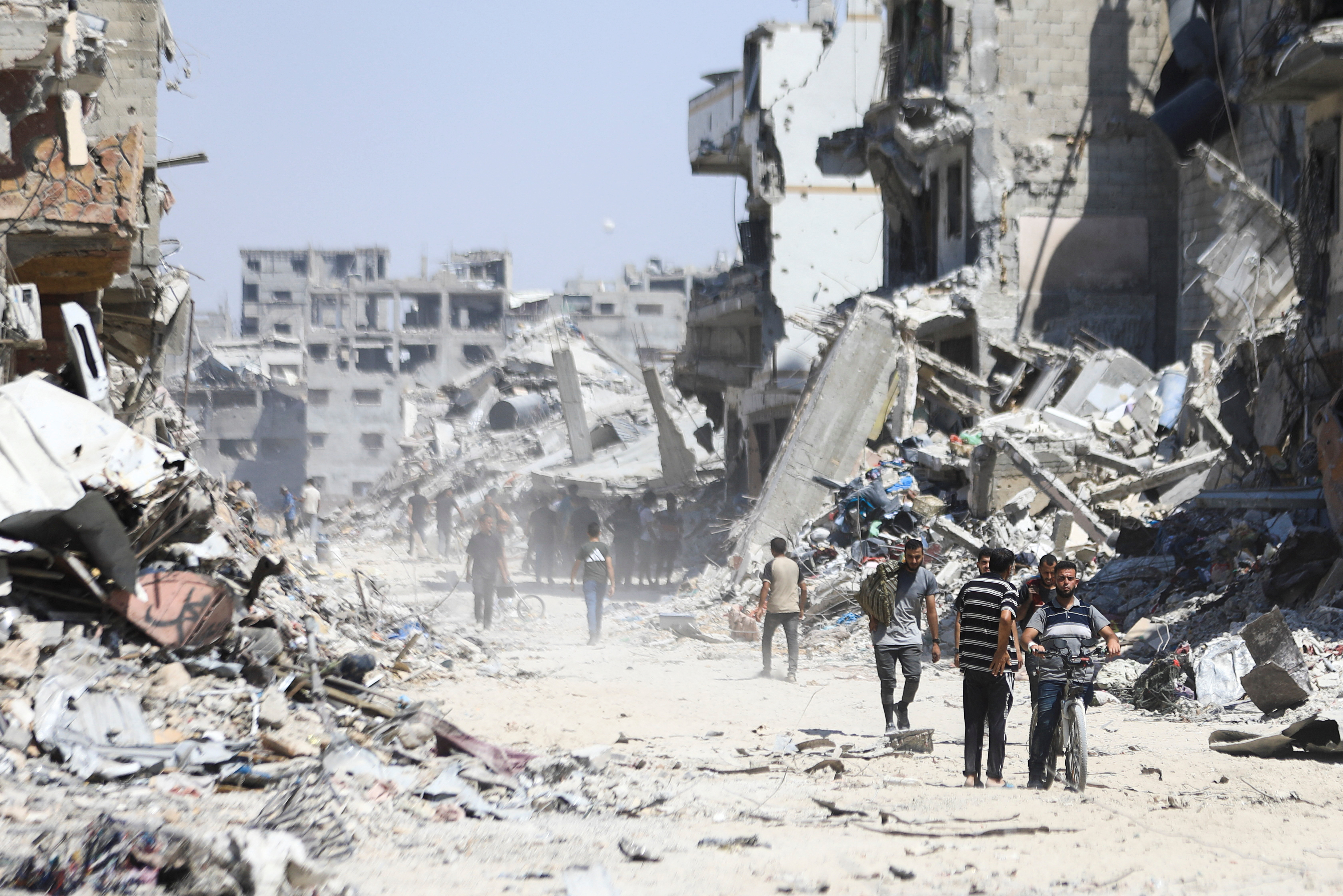 Palestinians make their way as they inspect the damage, after Israeli forces withdrew from Shejaiya neighborhood, following a ground operation, amid Israel-Hamas conflict, in eastern part of Gaza city, July 10, 2024. REUTERS/Dawoud Abu Alkas